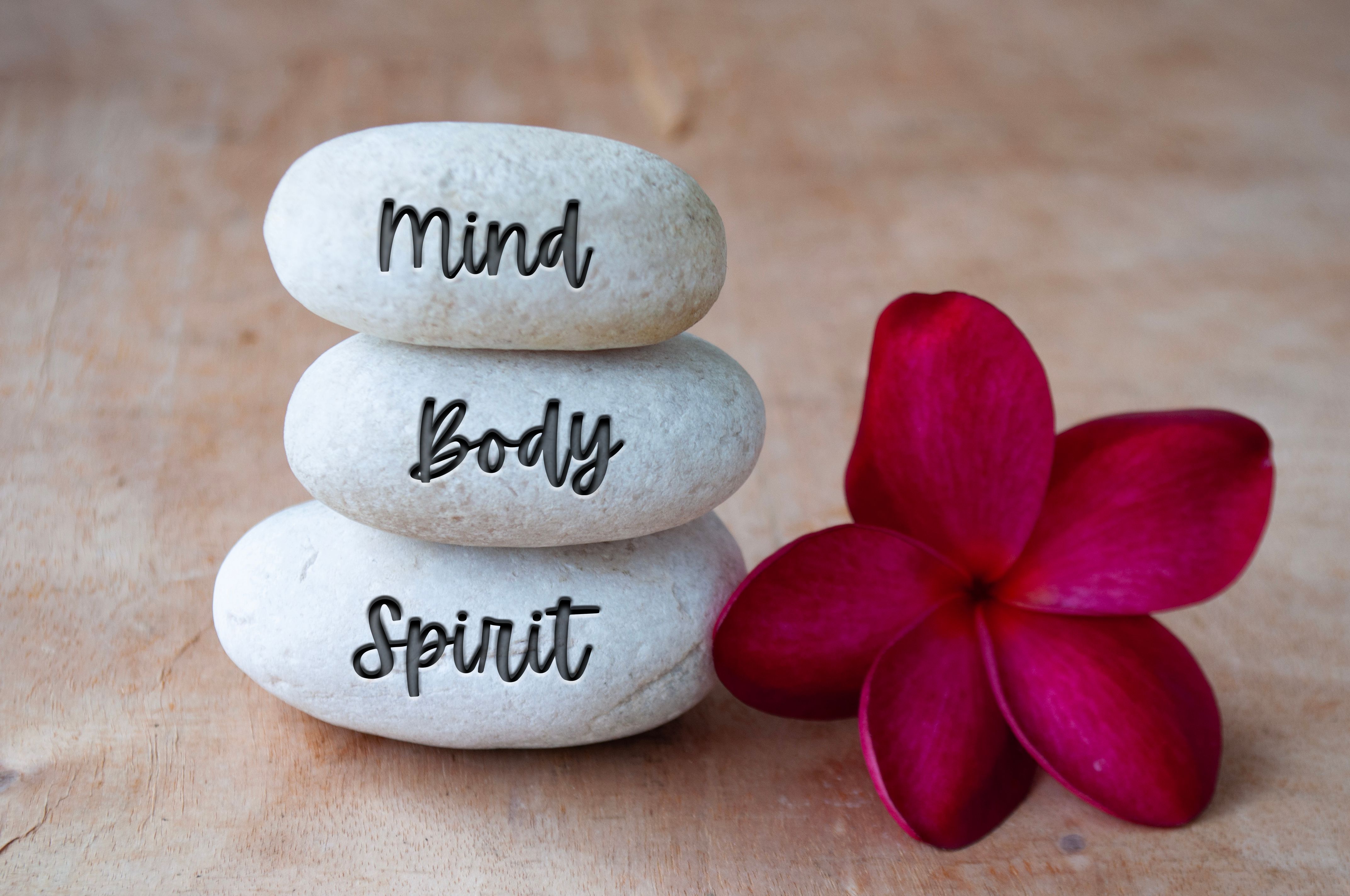 Mind, Body and Soul text engraved on white zen stones. Meditation and spa concept Mind, Body and Soul text engraved on white zen stones. Meditation and spa concept
