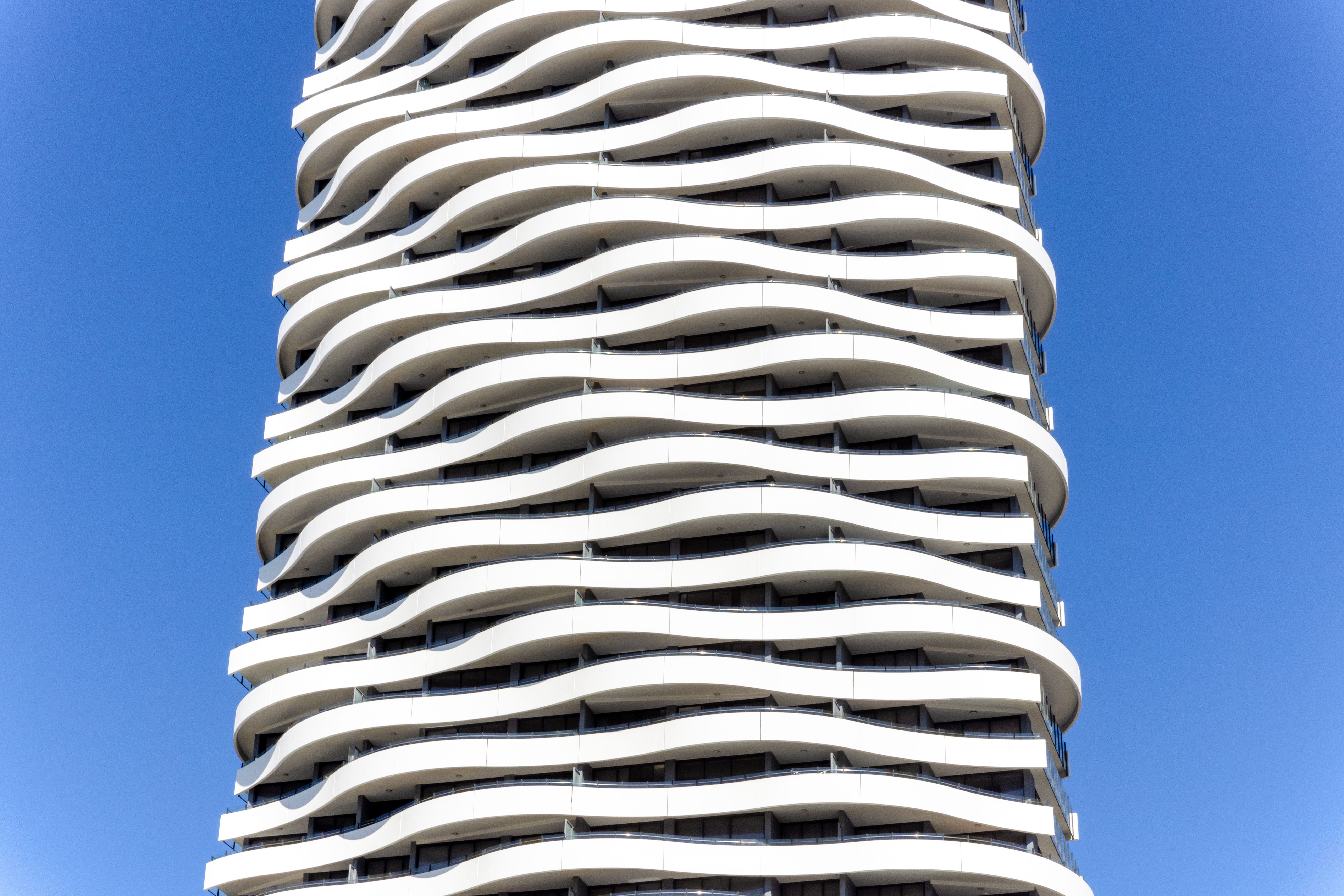 Closeup modern apartment building against blue sky, background with copy space