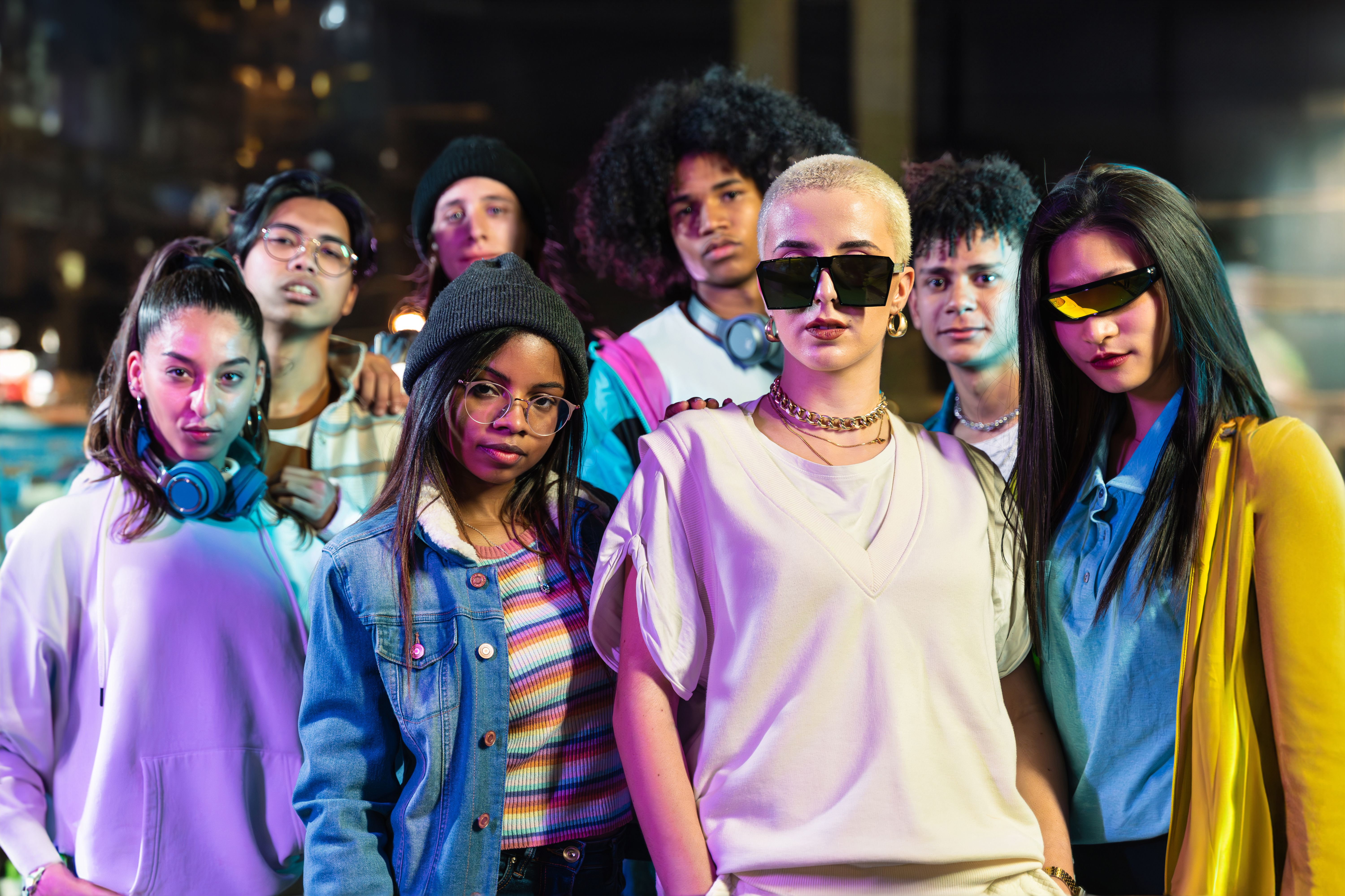 Group of trendy friends in modern funky style looking to camera in the city at night - Young Music Video Dance