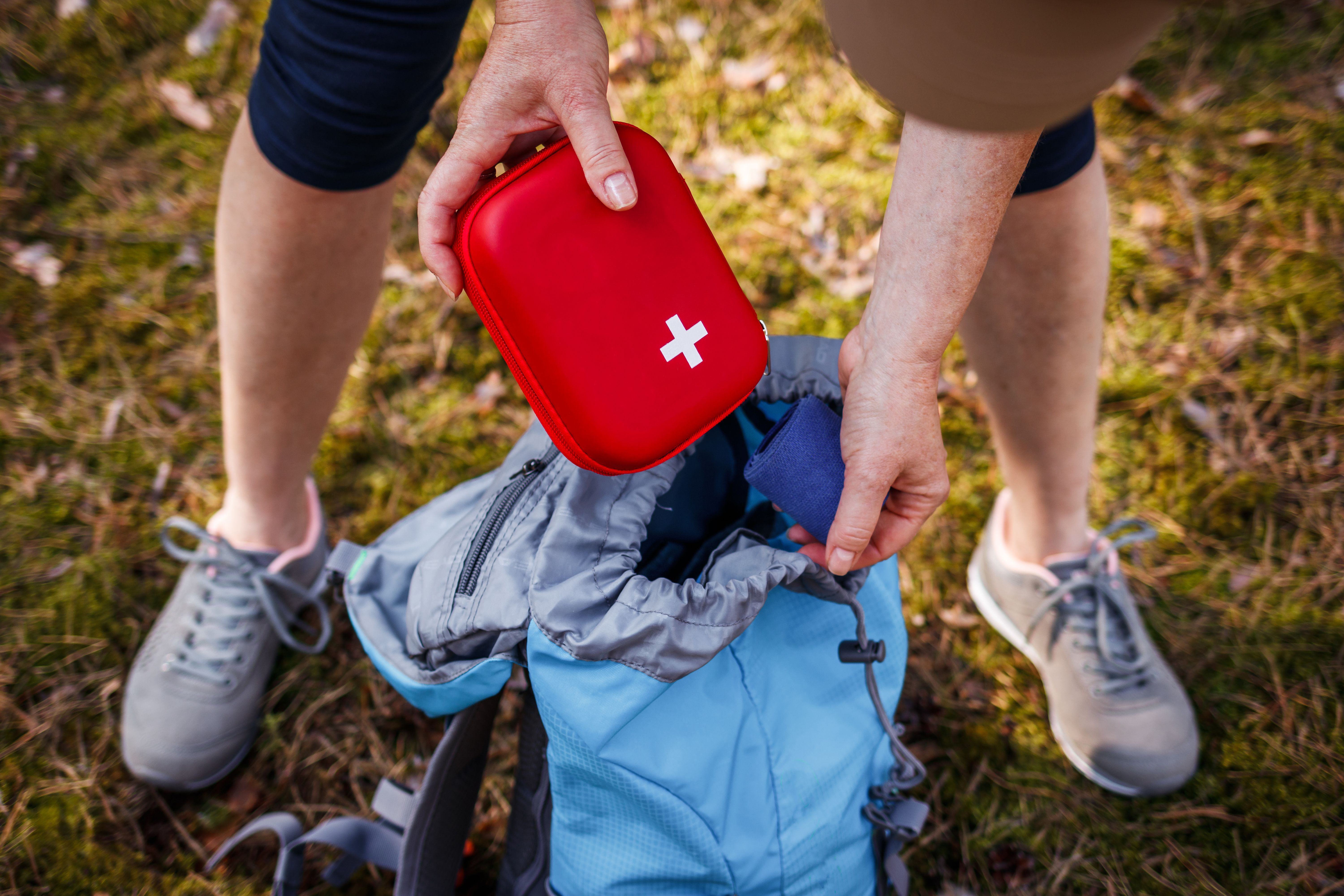 Woman taking out first aid kit from backpack