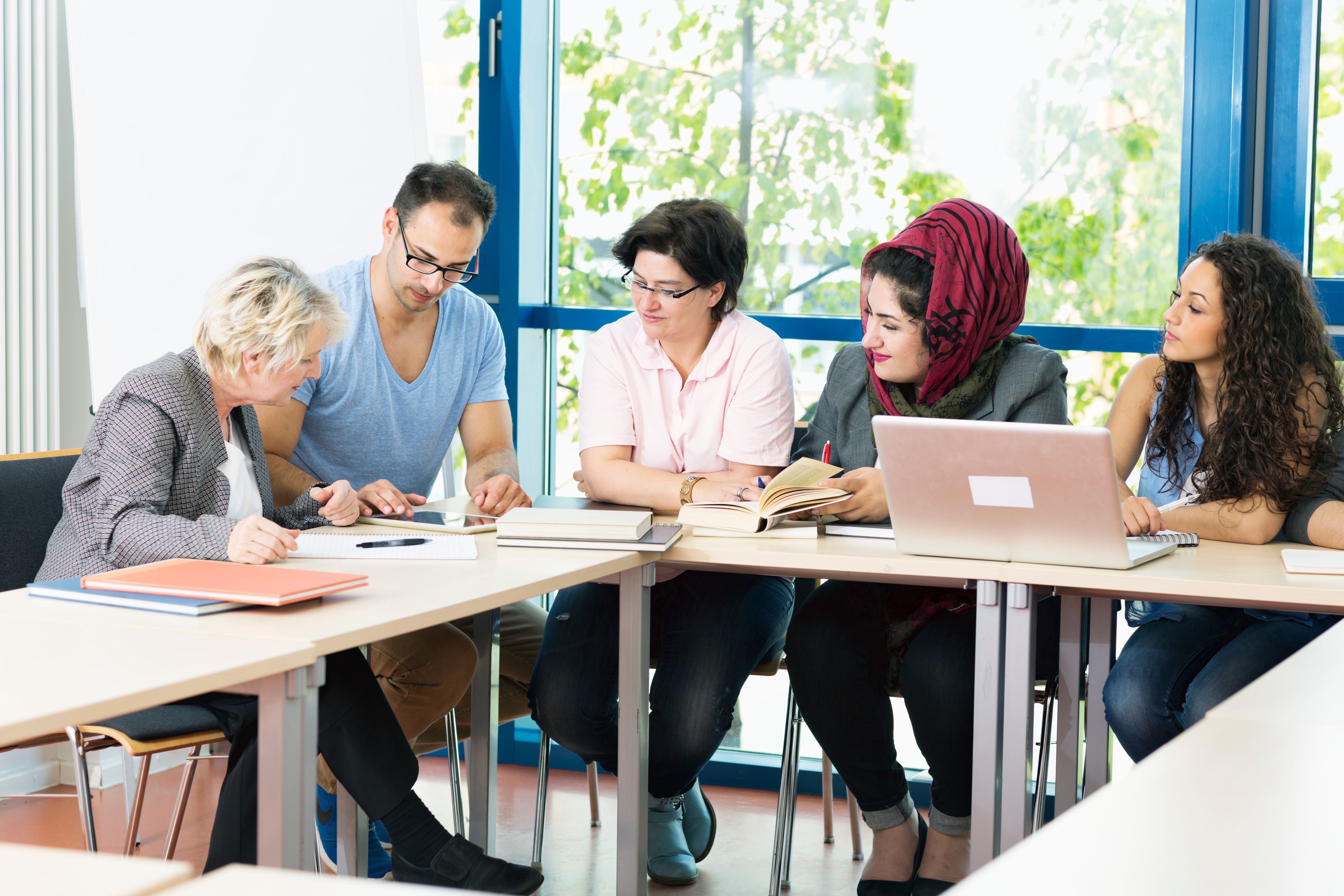 students and teacher  in classroom working with digital tablet