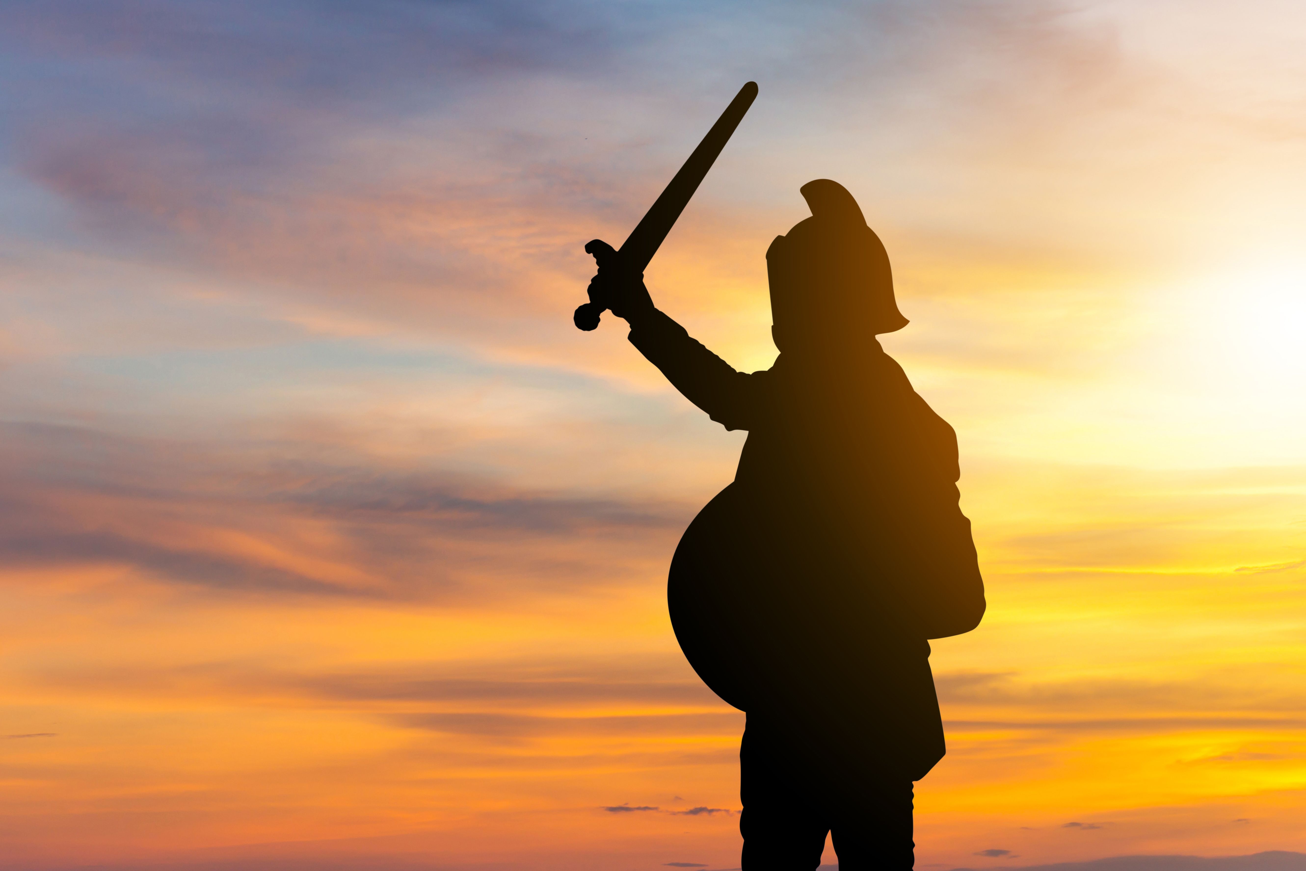 Silhouette of Businessman Knight Sword and Shield in Sunset Background, Fighting Business Warrior Concept. Silhouette of Businessman Knight Sword and Shield in Sunset Background, Fighting Business Warrior Concept.