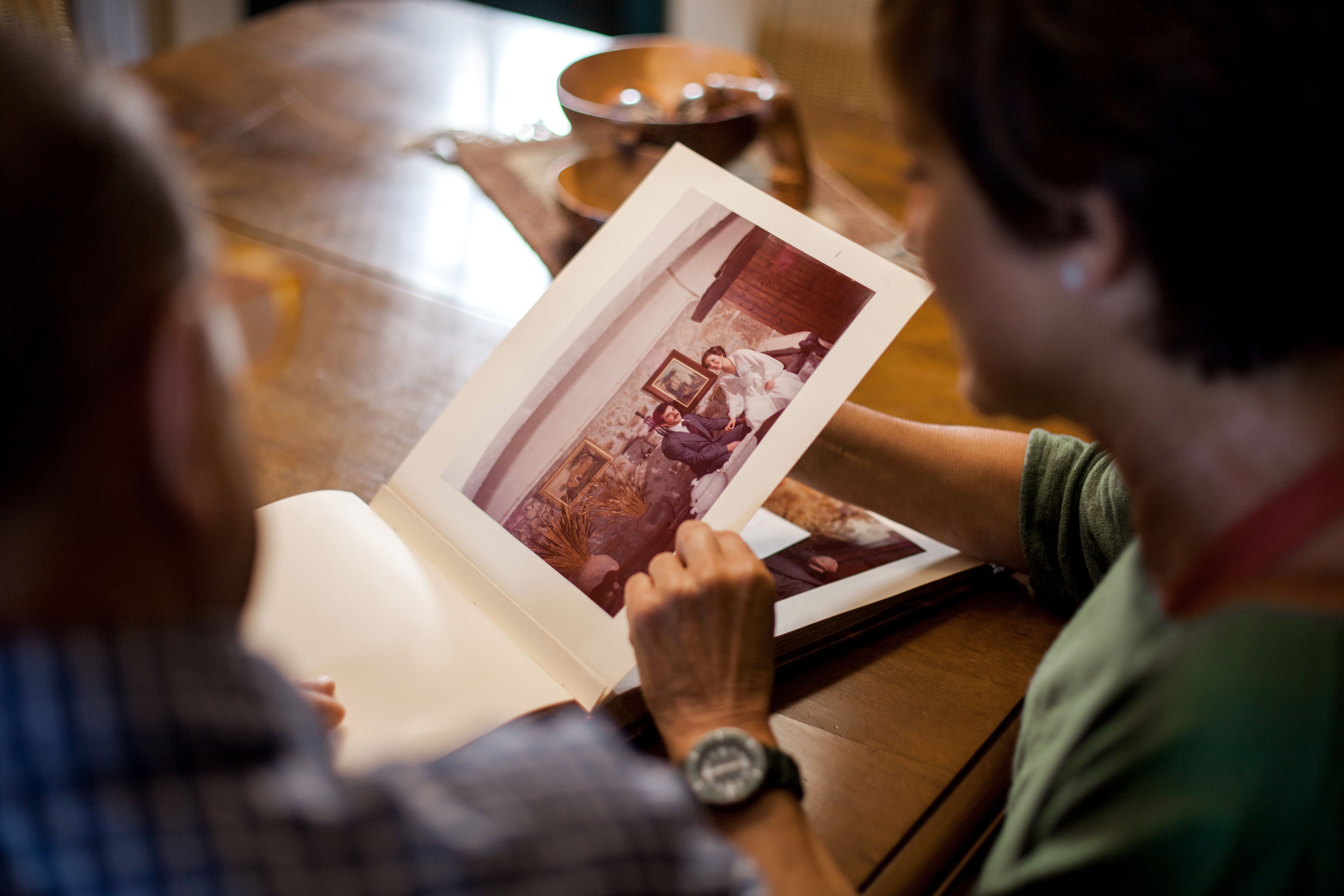 First point of view of a senior man looking at a old wedding photo album at christmas in central Texas First point of view of a senior man looking at a old wedding photo album at christmas in central Texas