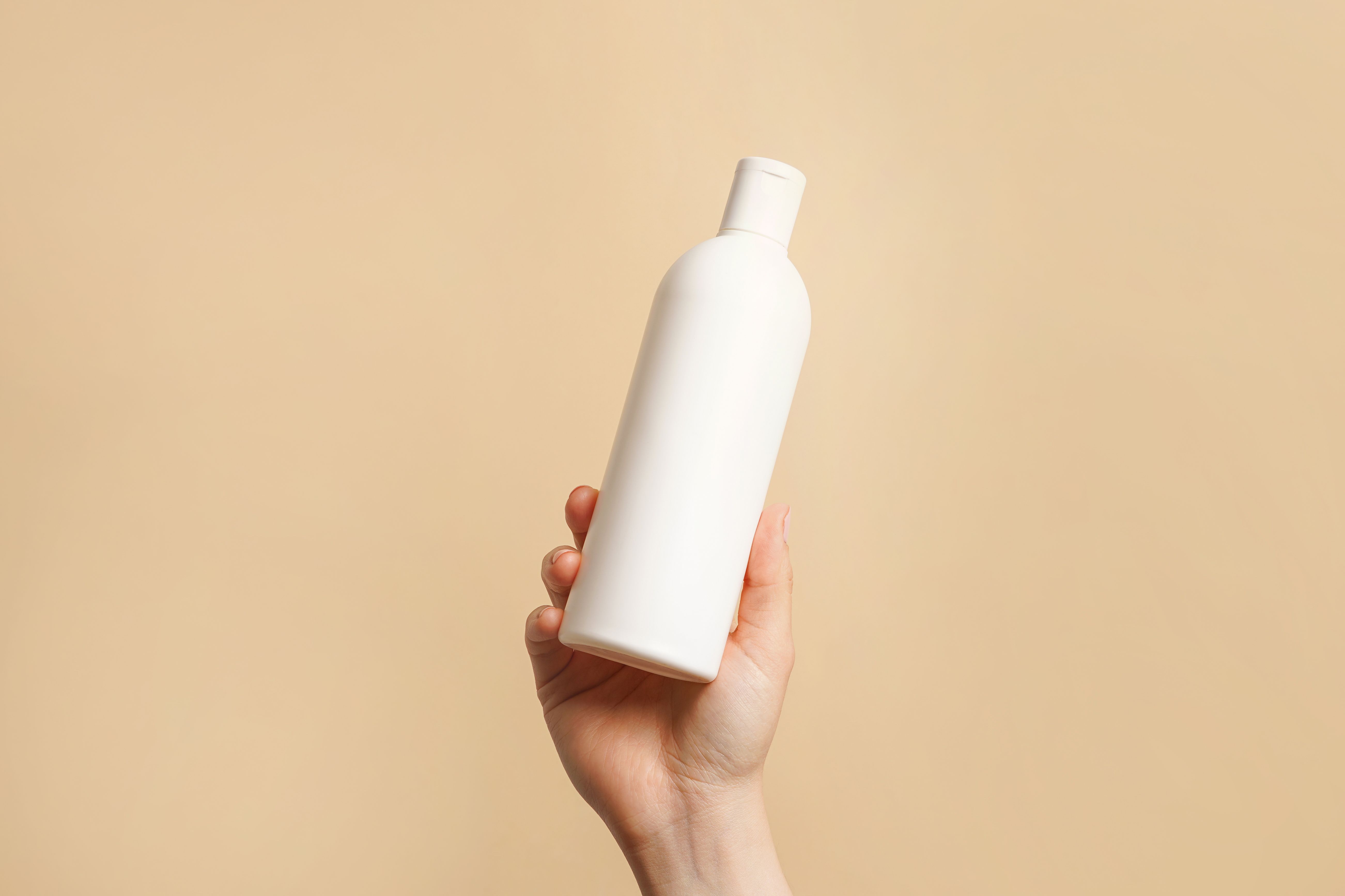 hands holding shampoo