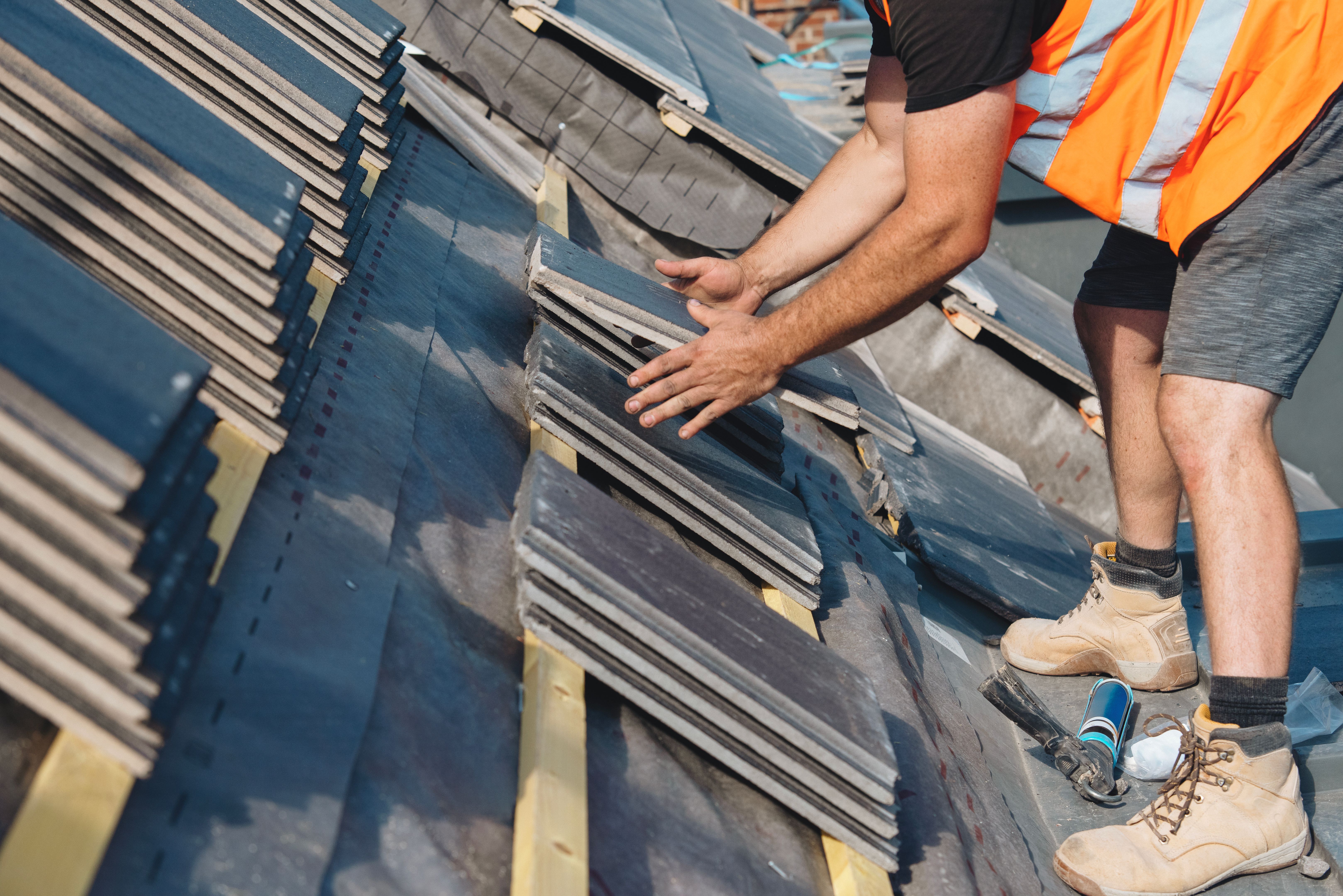 Roofing works in progress as new covering of  tiled roof done by roofer