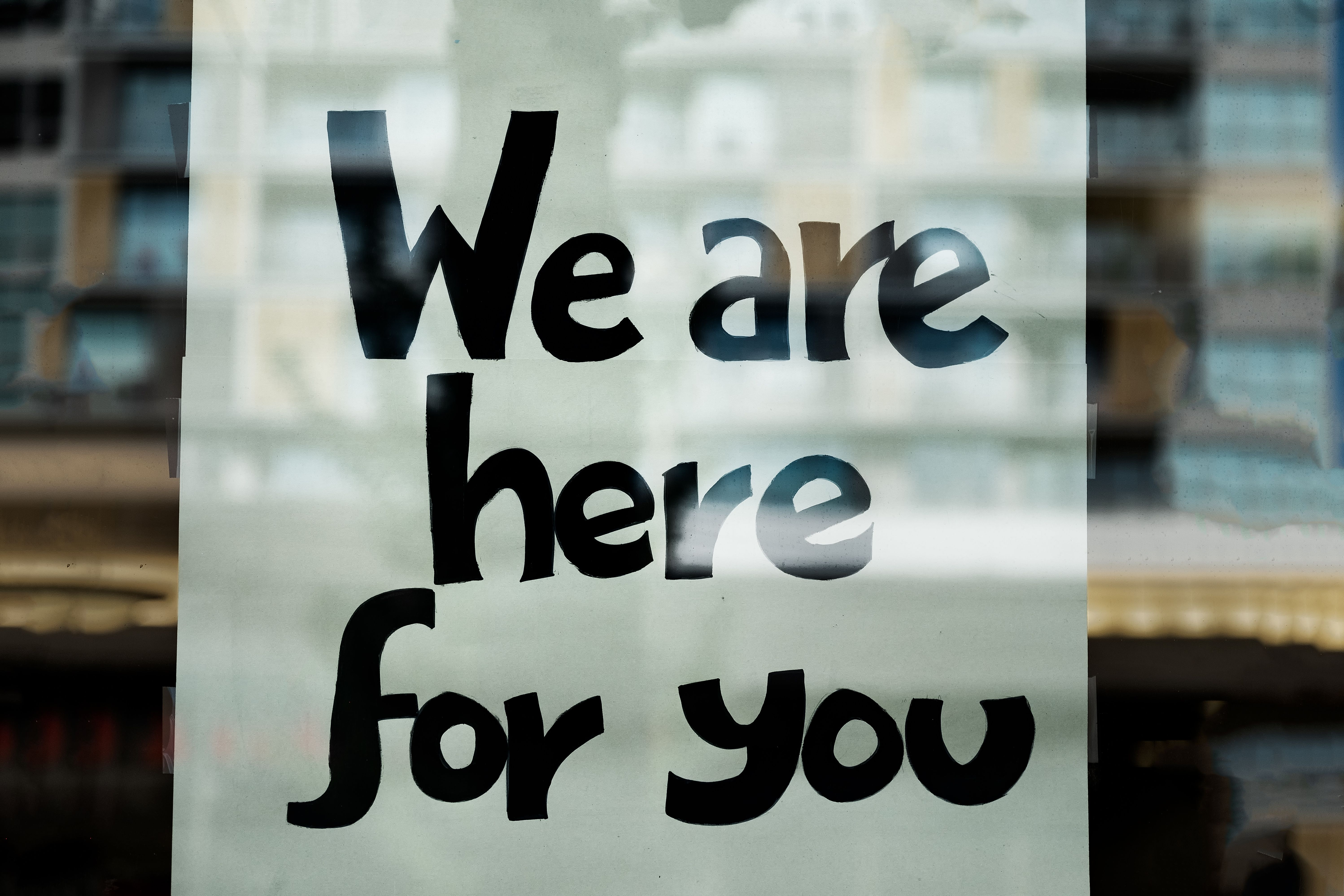 We Are Here For You Sign on Window of Business We Are Here For You Sign on Window of Business