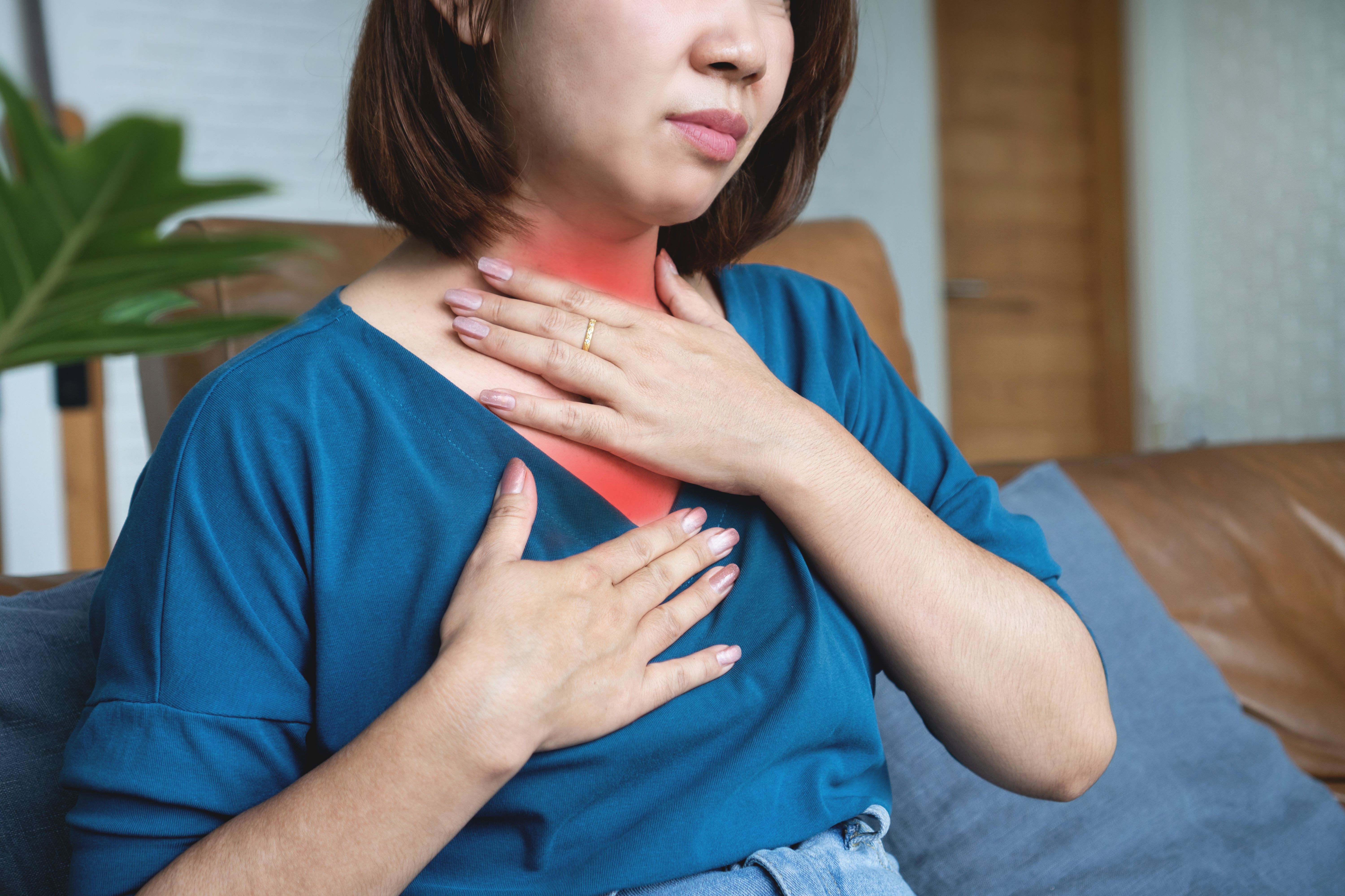 Asian woman suffering from gastroesophageal reflux disease feeling sore throat
