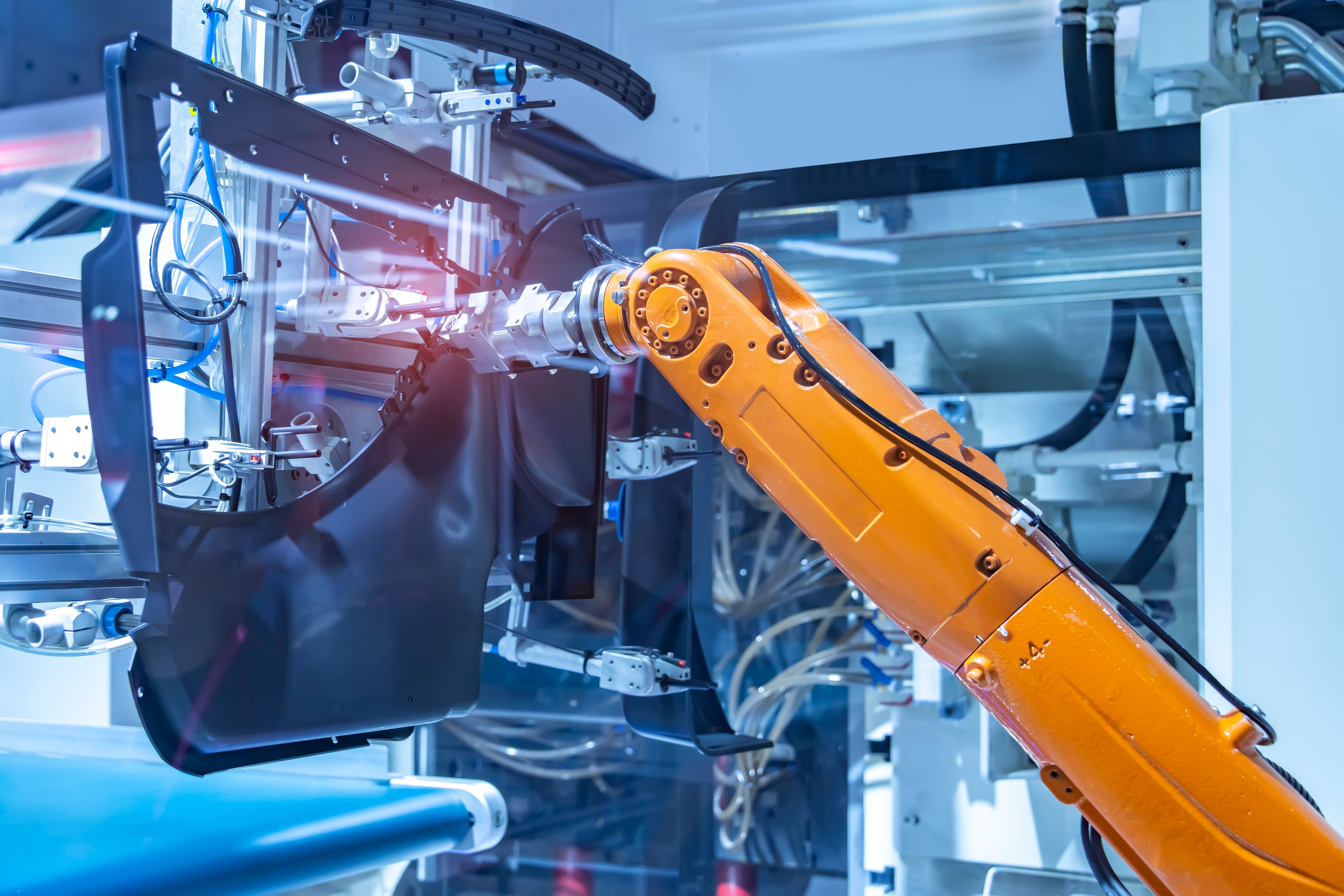 Industrial robot arm handling a part inside a guarded cell