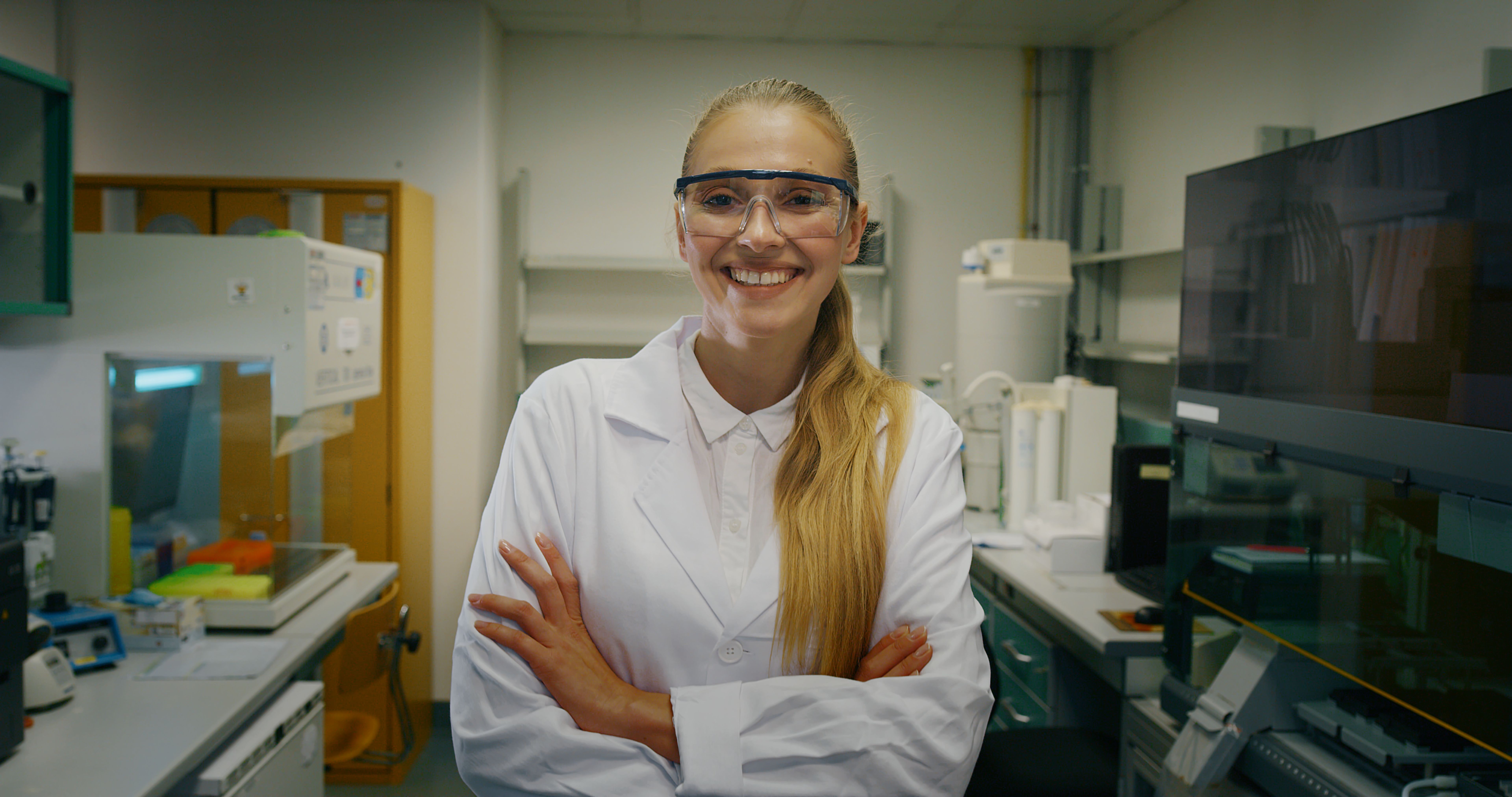 Portrait of blond female scientist is analyzing with a pipette a liquid to extract the DNA and molecules in the test tubes in laboratory. Portrait of blond female scientist is analyzing with a pipette a liquid to extract the DNA and molecules in the test tubes in laboratory.