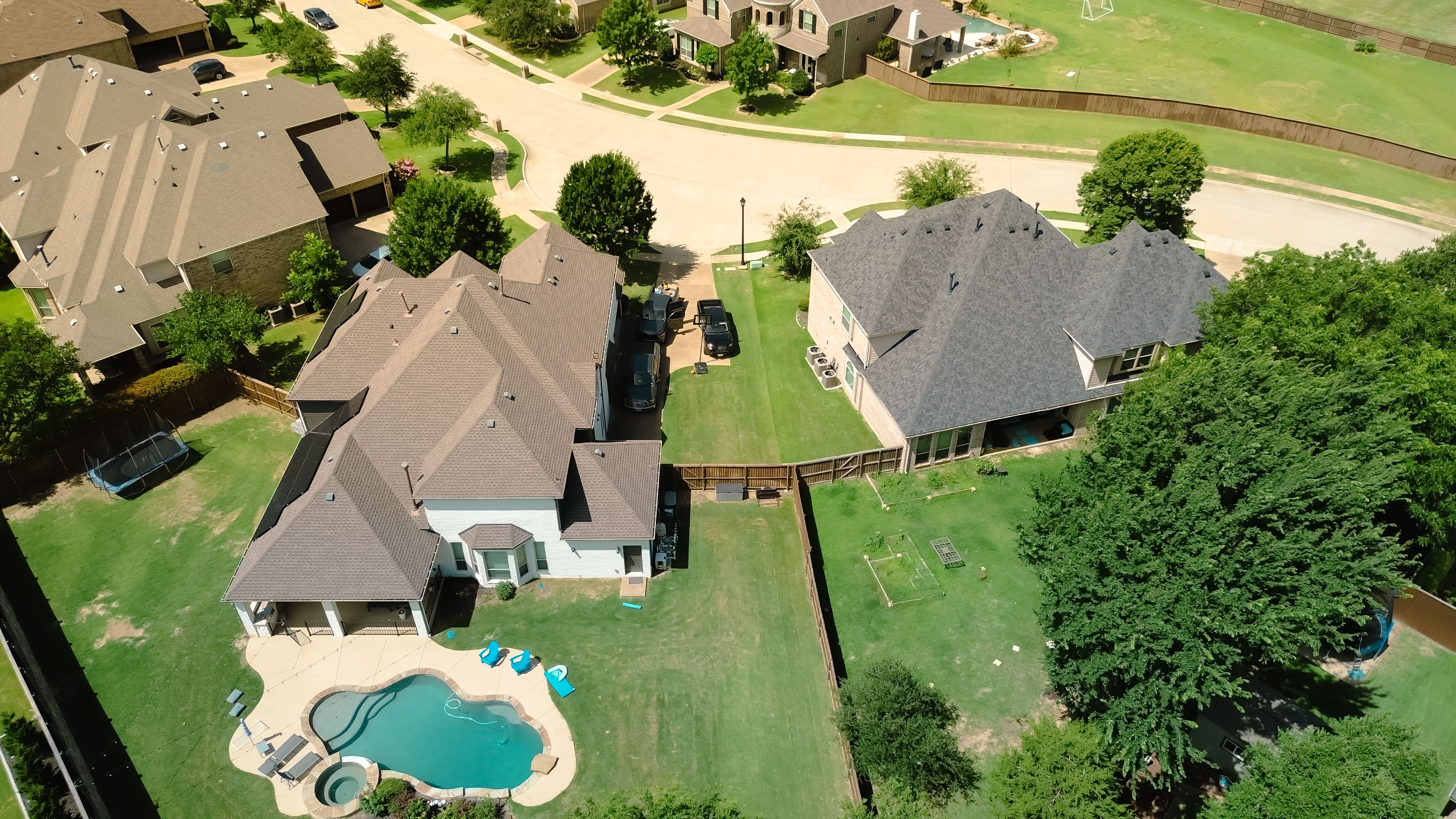 Luxury modern suburban home with spacious fenced backyard, resort style swimming pool, patio furniture, open lawn space designed for family recreation and outdoor relaxation in Flower Mound, Texas