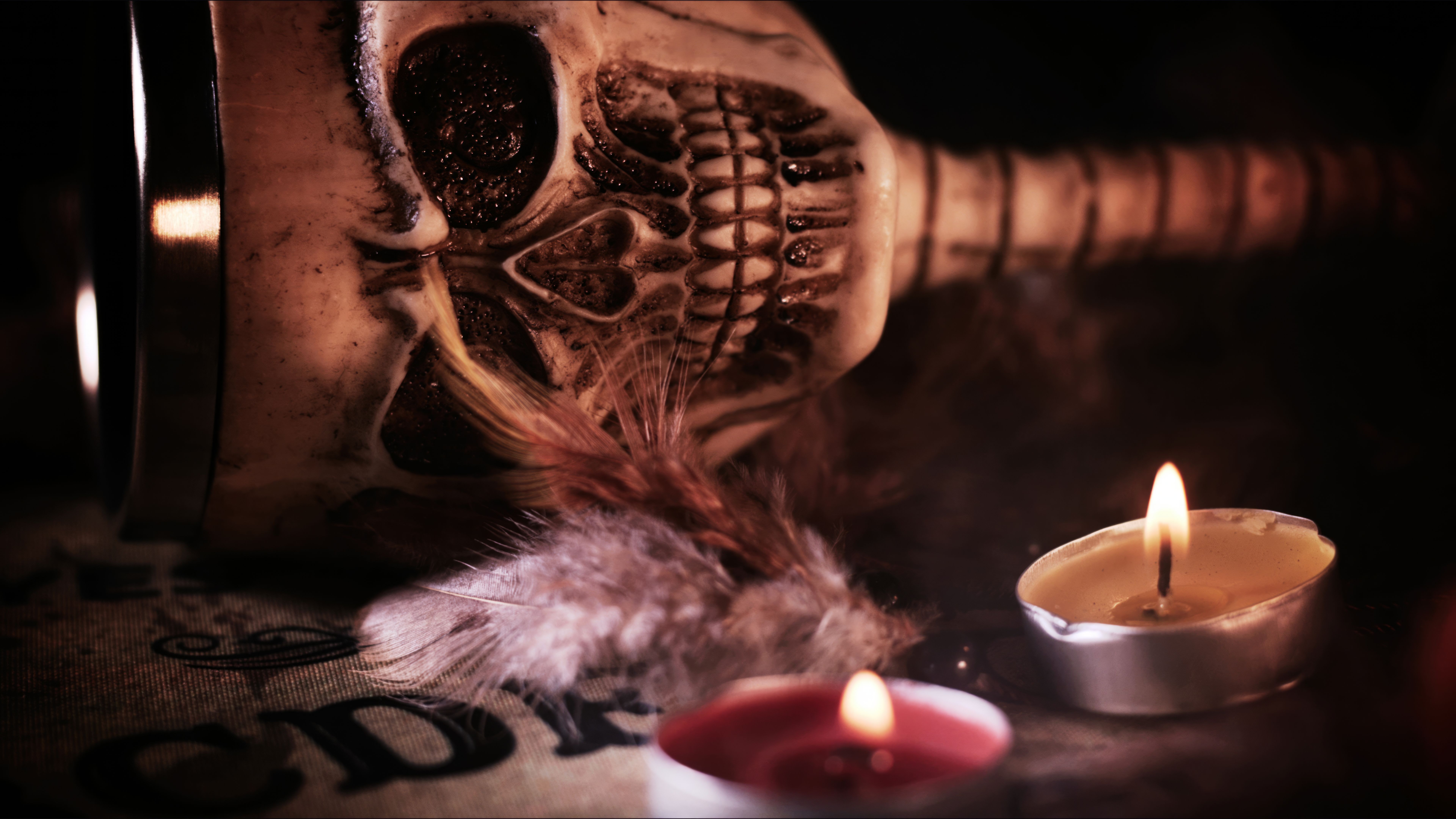 Creepy Skull on a Witchcraft Ouija Board and Candles Creepy Skull on a Witchcraft Ouija Board and Candles