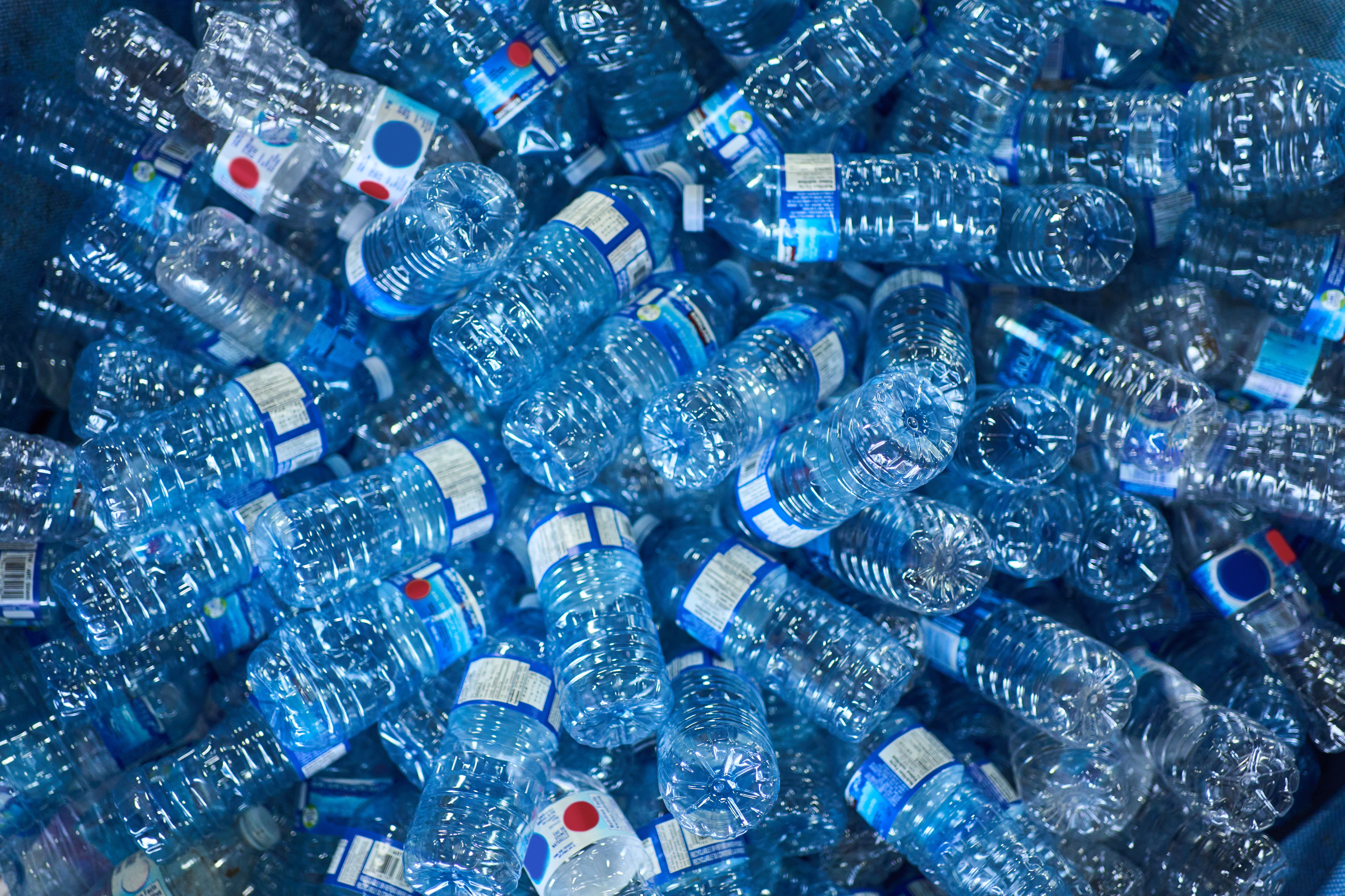 Plastic water bottles sitting piled up in a recycling center
