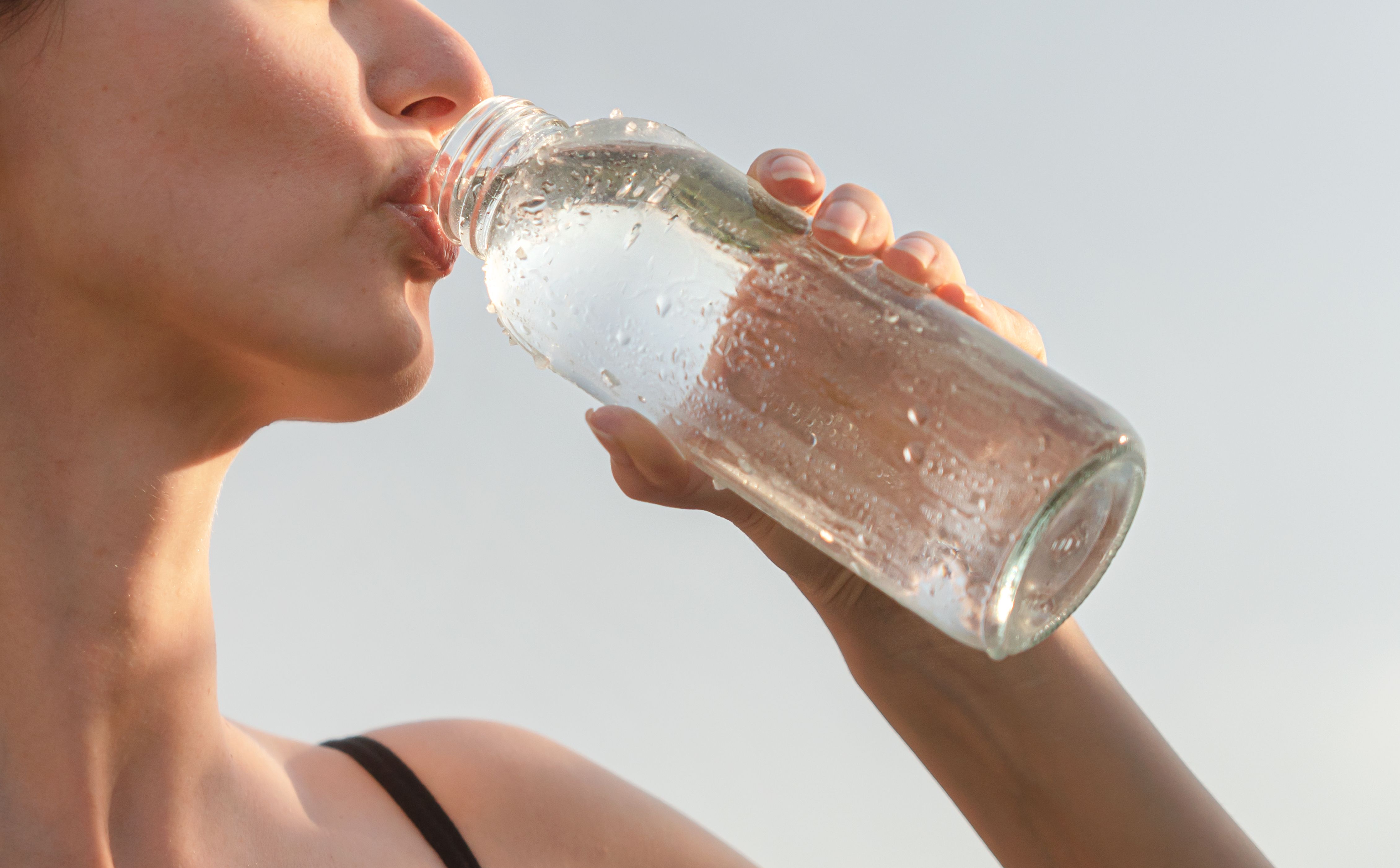Mujer bebiendo agua fresca de una botella