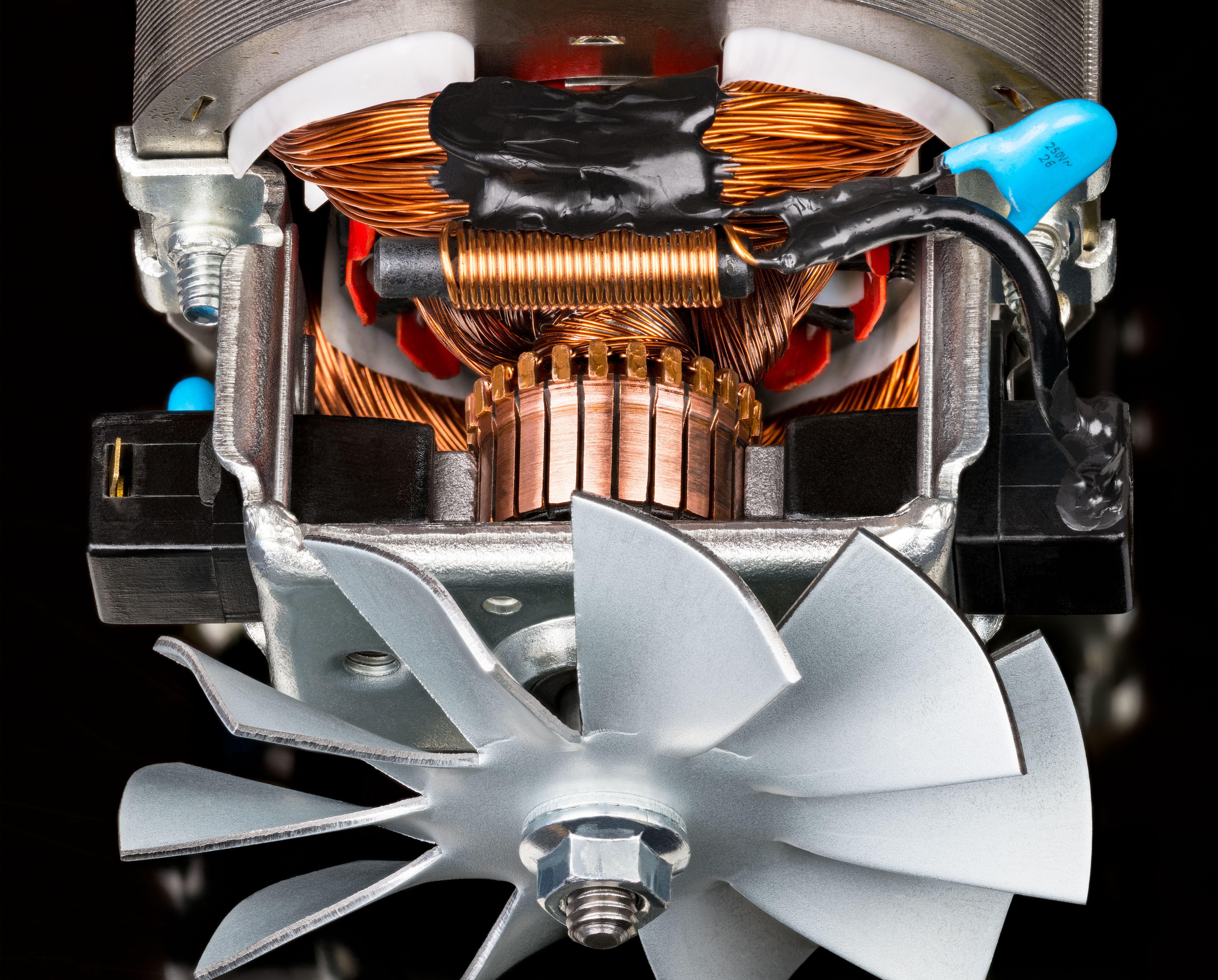 Closeup of electric DC motor inside and fan metal vanes on steel shaft