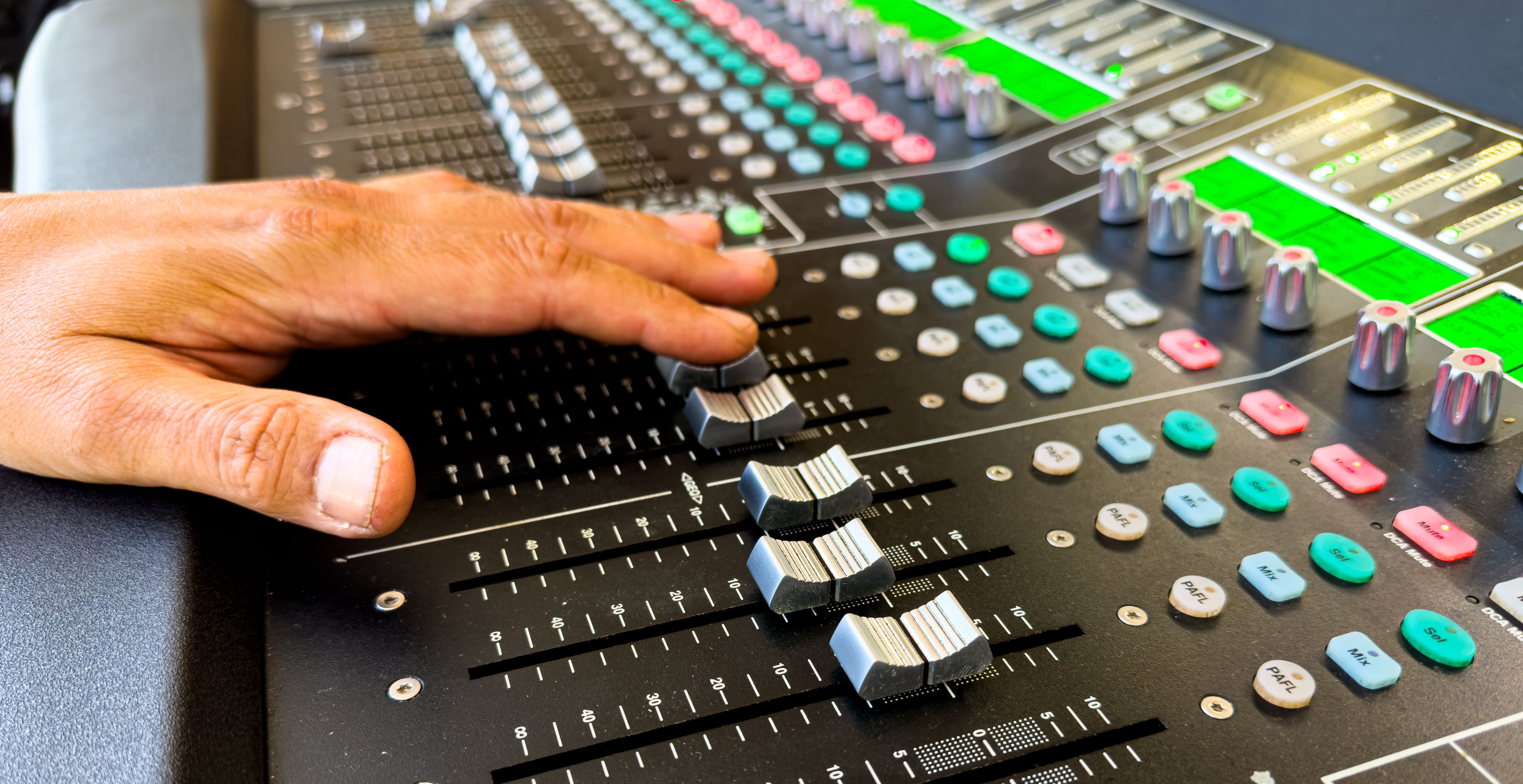 Sliders and buttons on Audio Mixing Desk at live event.