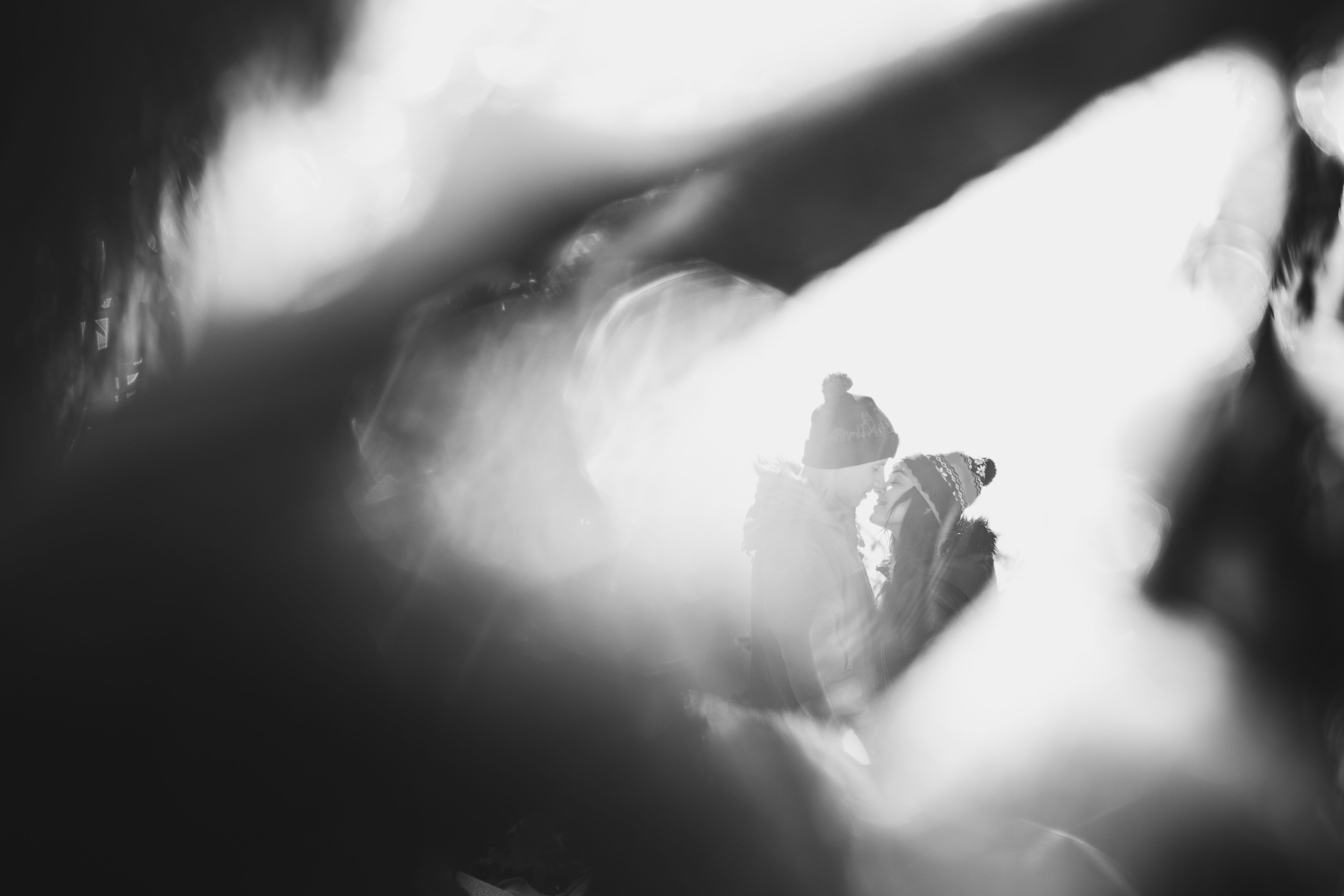 Close and emotional portrait of loving couple at winter. Through flickering bokeh