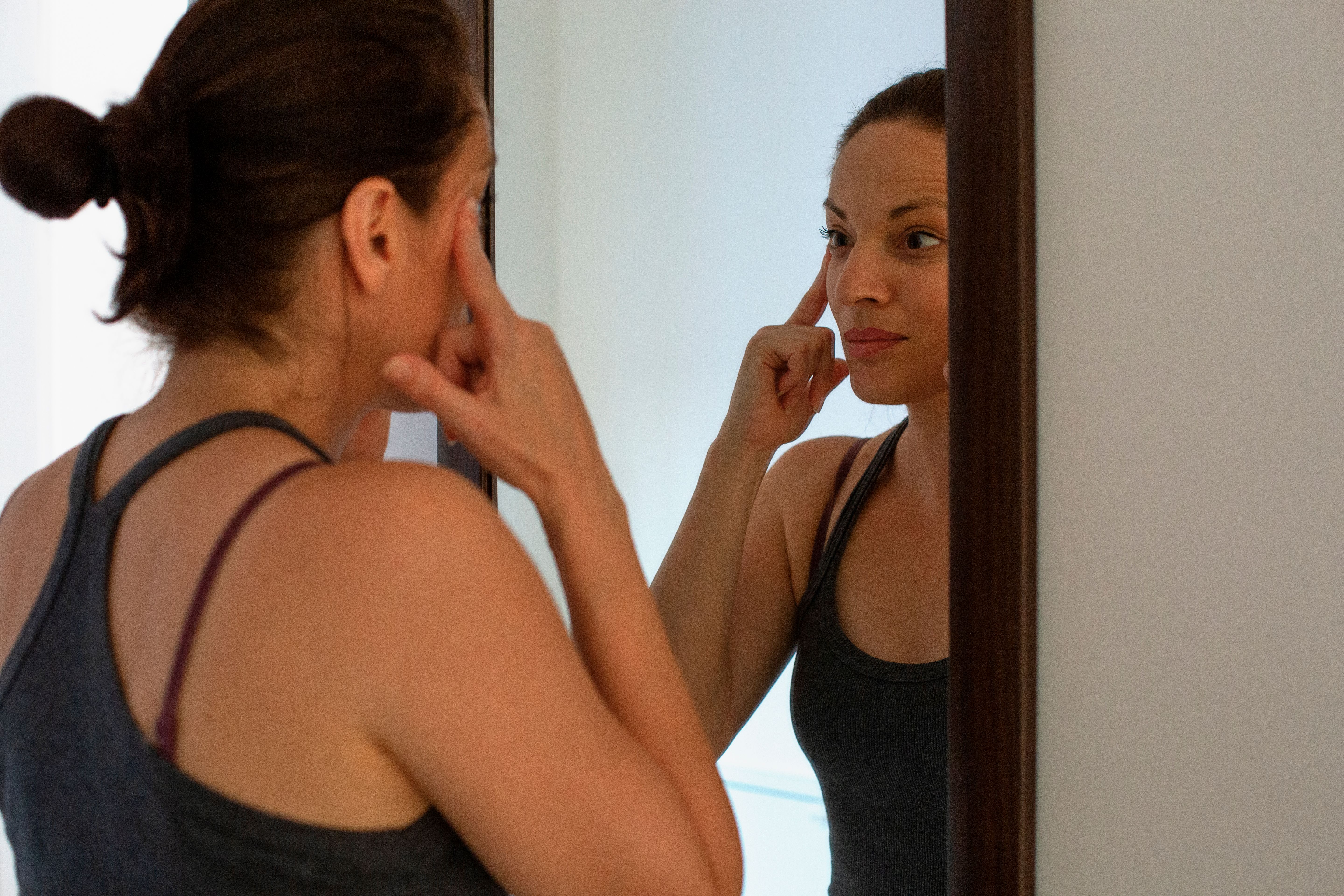 Woman stretching under eye wrinkles Woman stretching under eye wrinkles