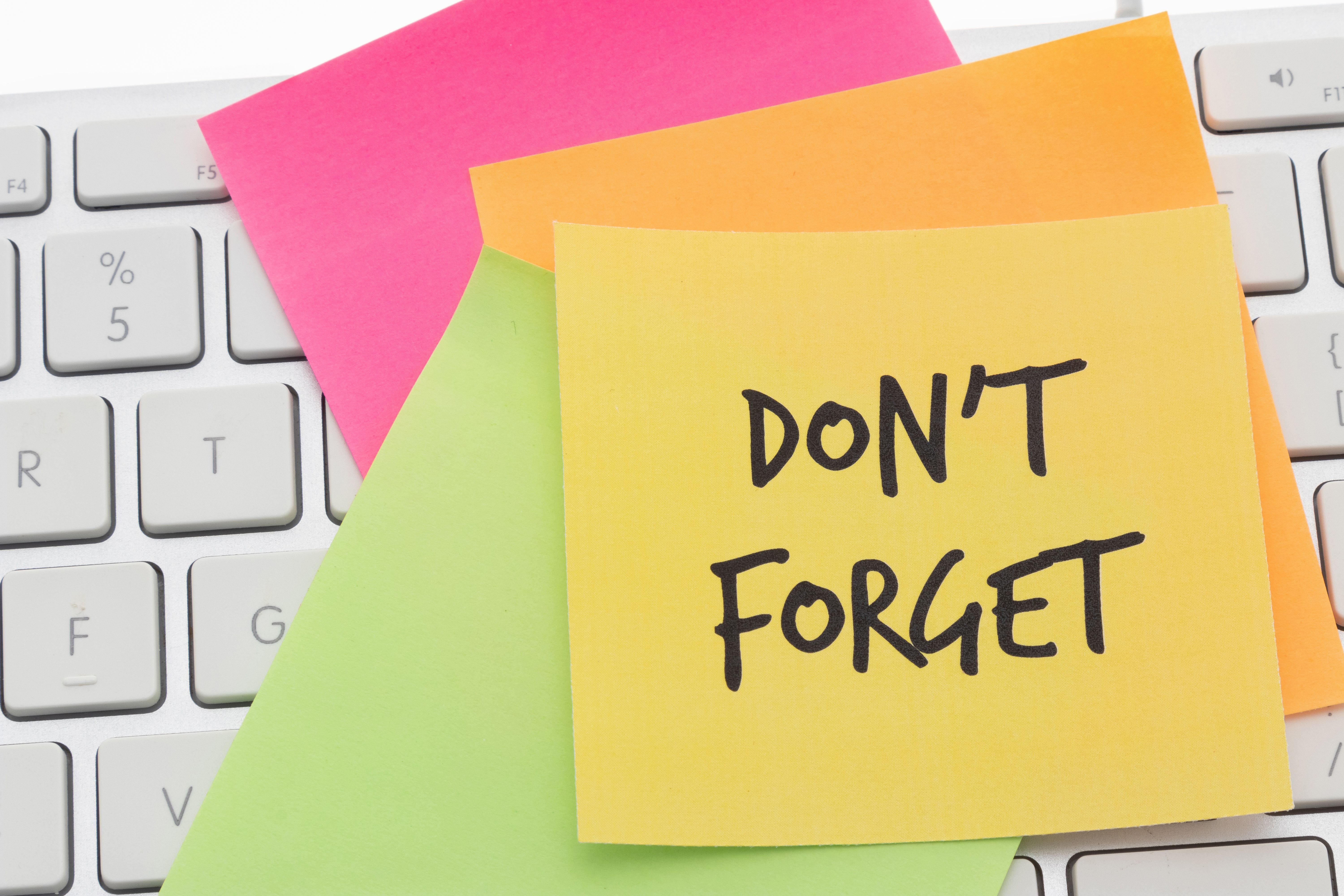 An adhesive note on a computer keyboard - Dont forget