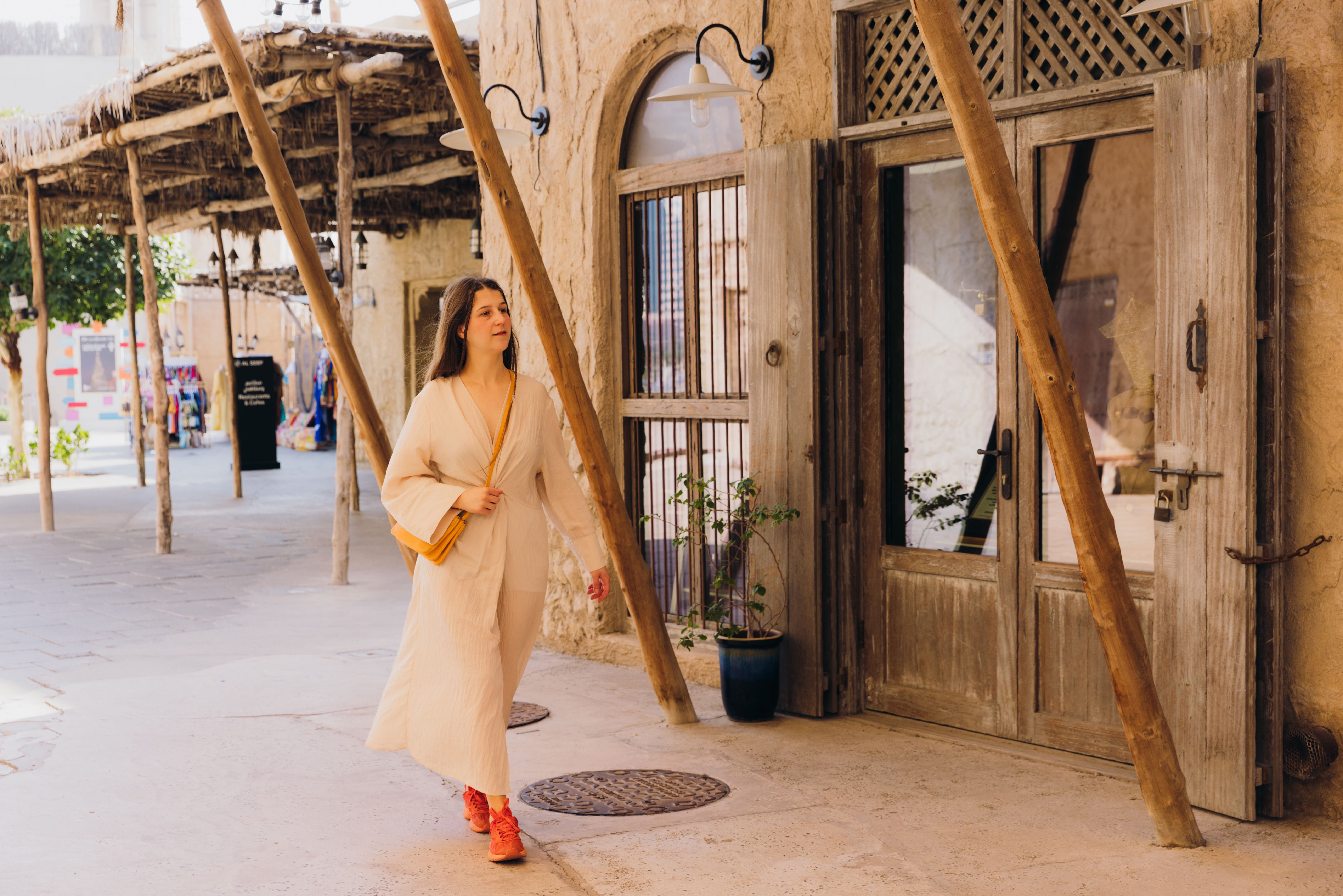 Woman in Dress Exploring Old Town of Dubai City, bastakiya Woman in Dress Exploring Old Town of Dubai City, bastakiya