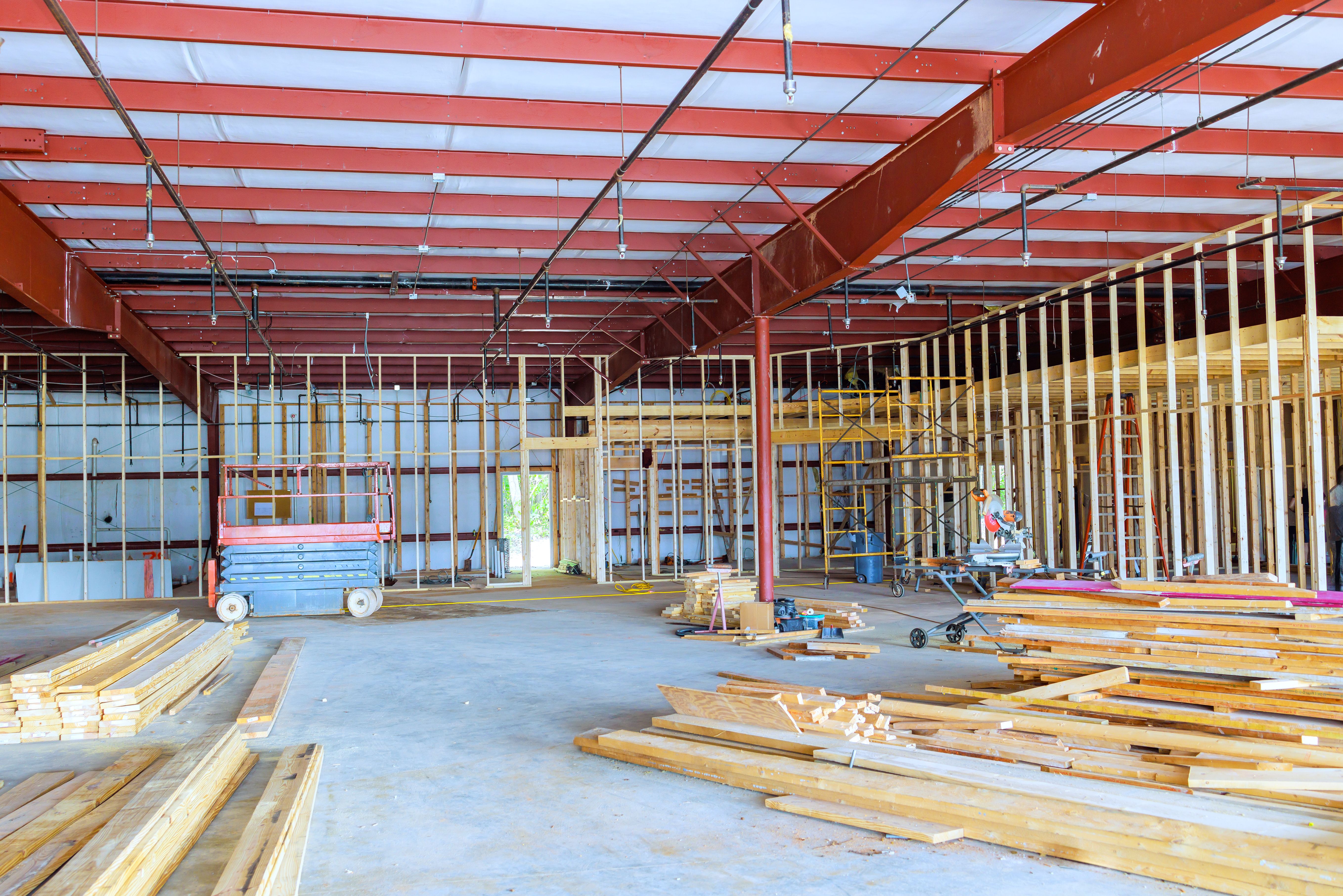 Construction is currently underway in a large room of warehouse to reconstruct interior