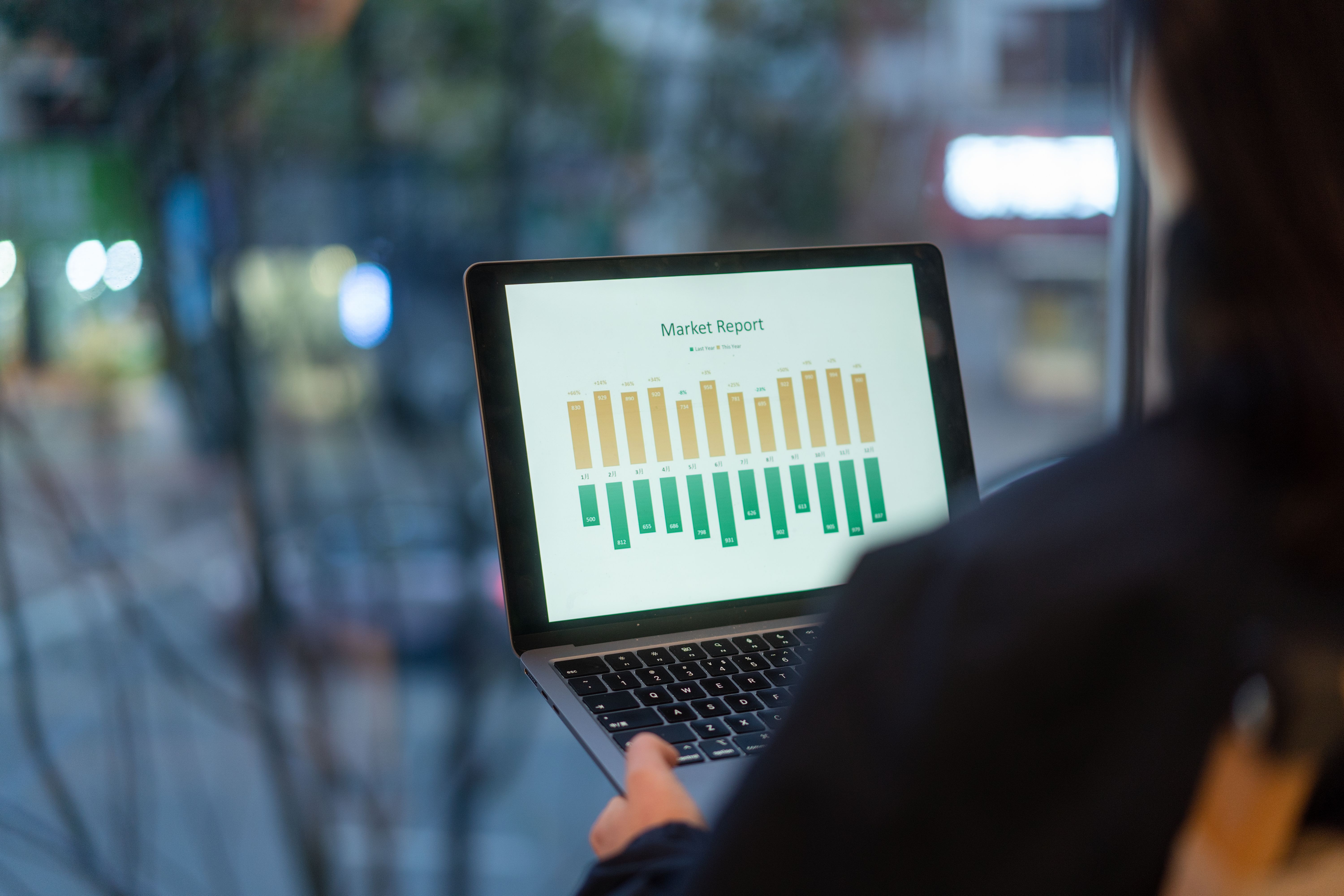 asian female working on laptop in office beside window