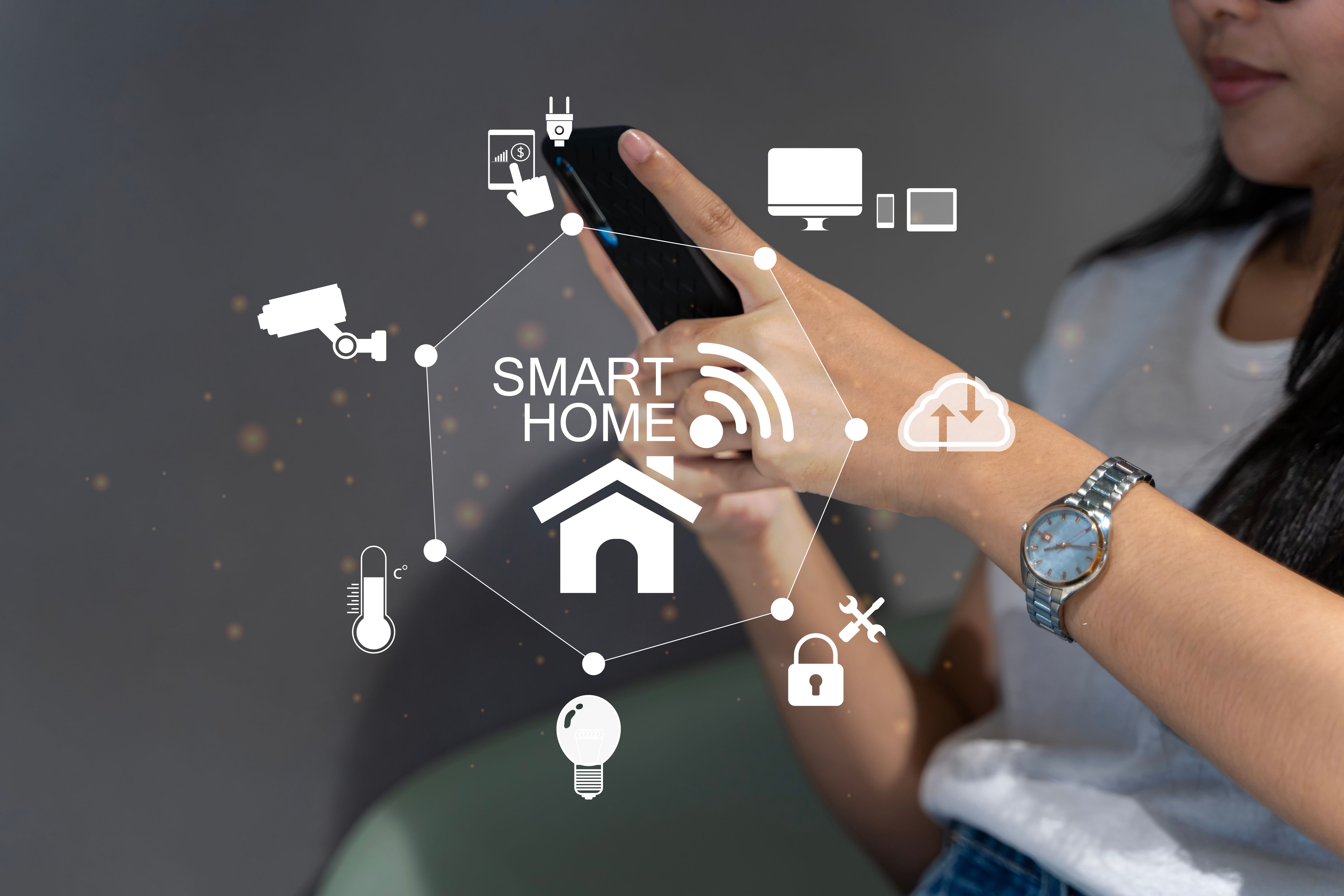 Woman's hands holding smartphone in bedroom with couple exposure of smart home interface, automation concept. Smart home automation control system.