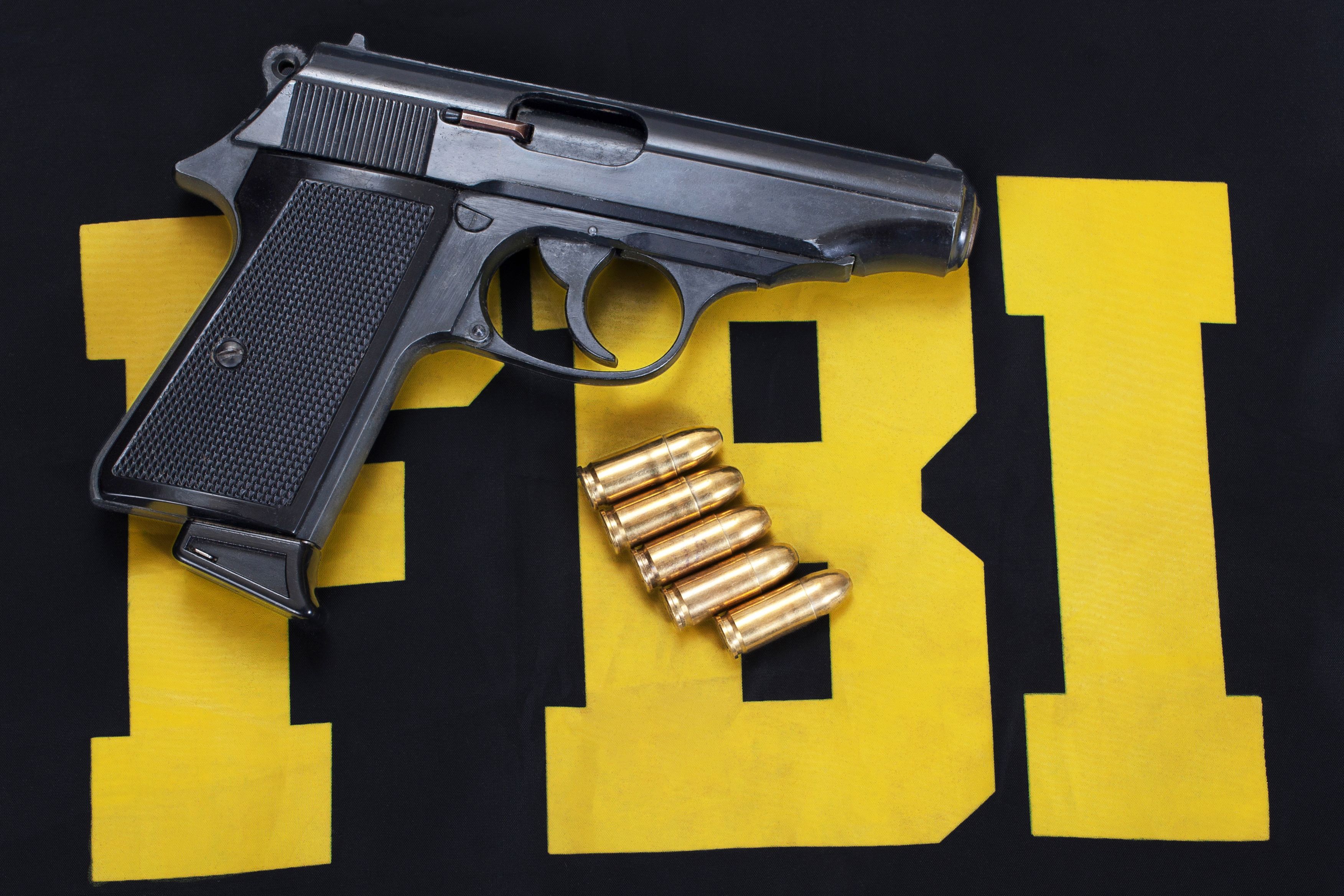FBI concept with handgun and ammunition on black uniform FBI concept with handgun and ammunition on black uniform