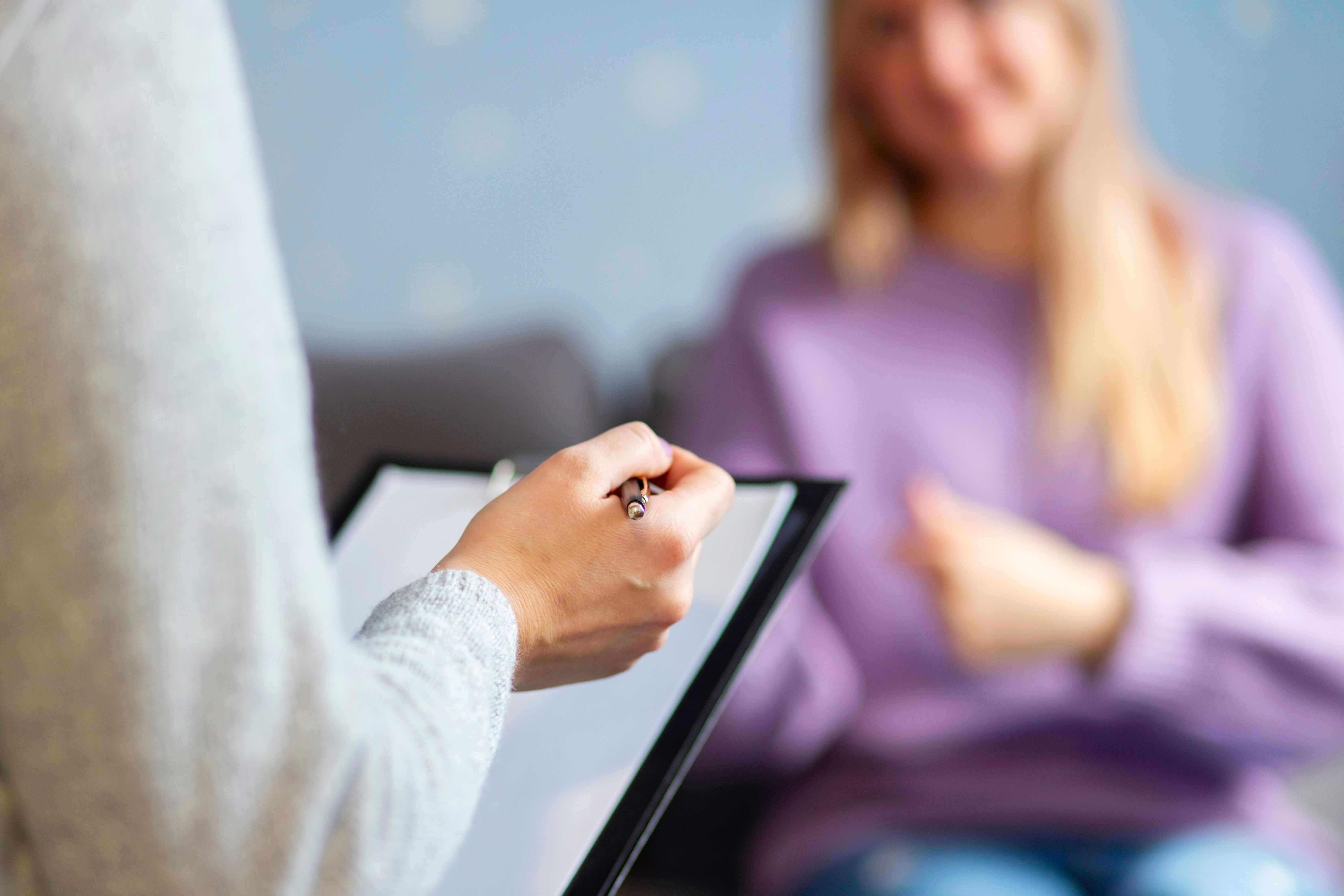 Psychotherapy session, a woman is talking with her hypnotherapist at her initial consultation. Selective focus Psychotherapy session, a woman is talking with her hypnotherapist at her initial consultation. Selective focus