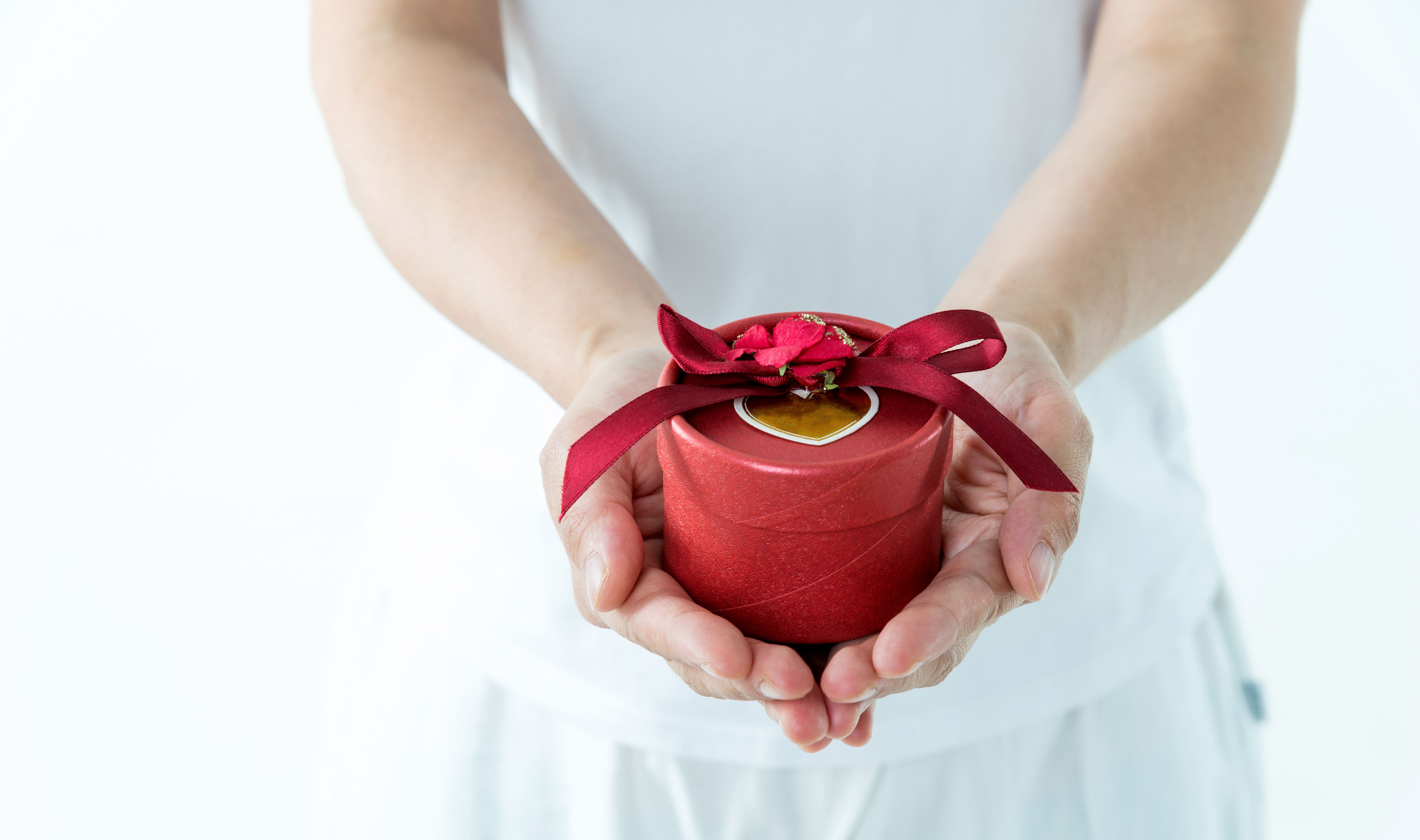 Woman hands holding a gift box on white background