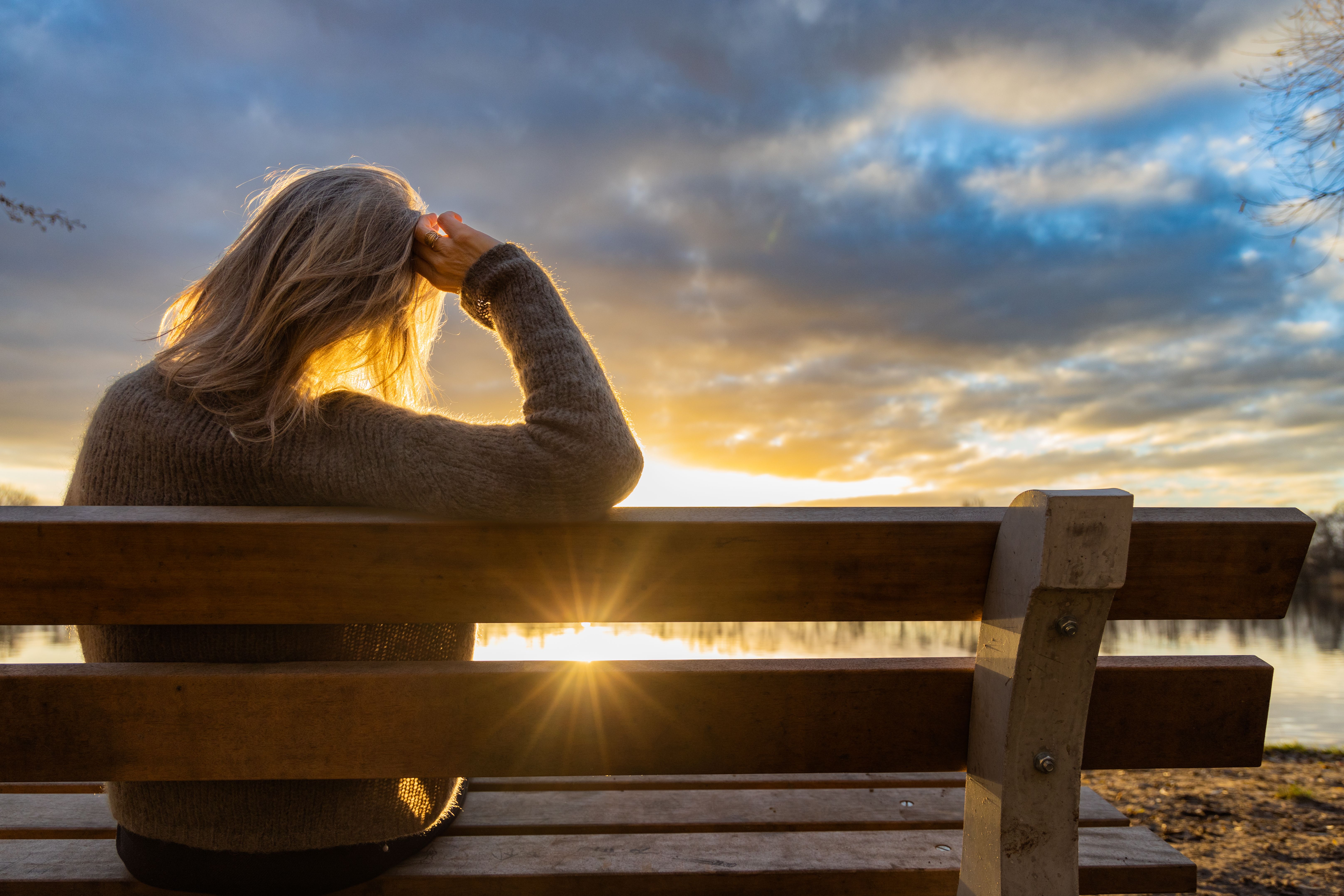 woman walking and resting at the lake at sunset