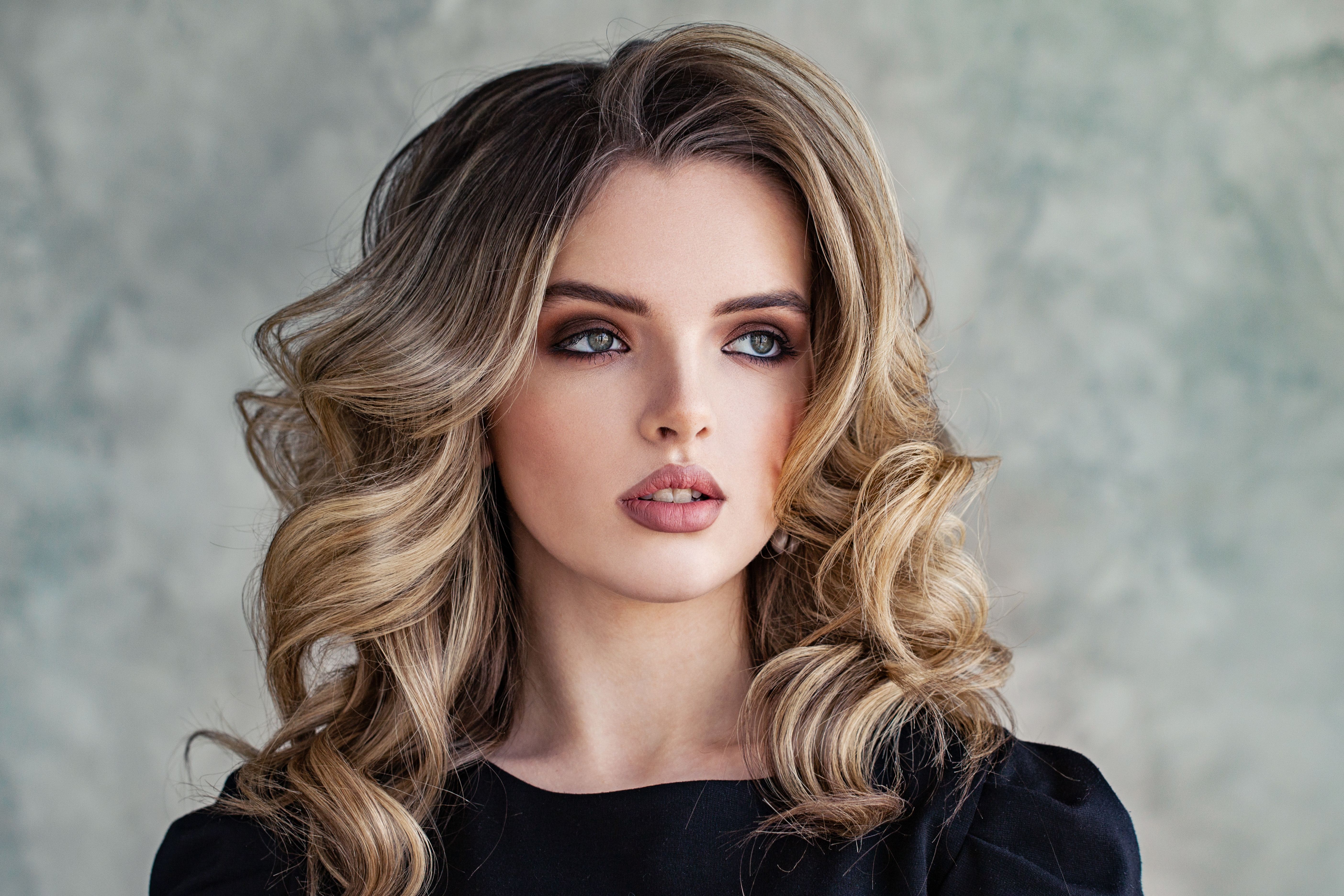 Lovely woman model with curly hairstyle on gray background portrait