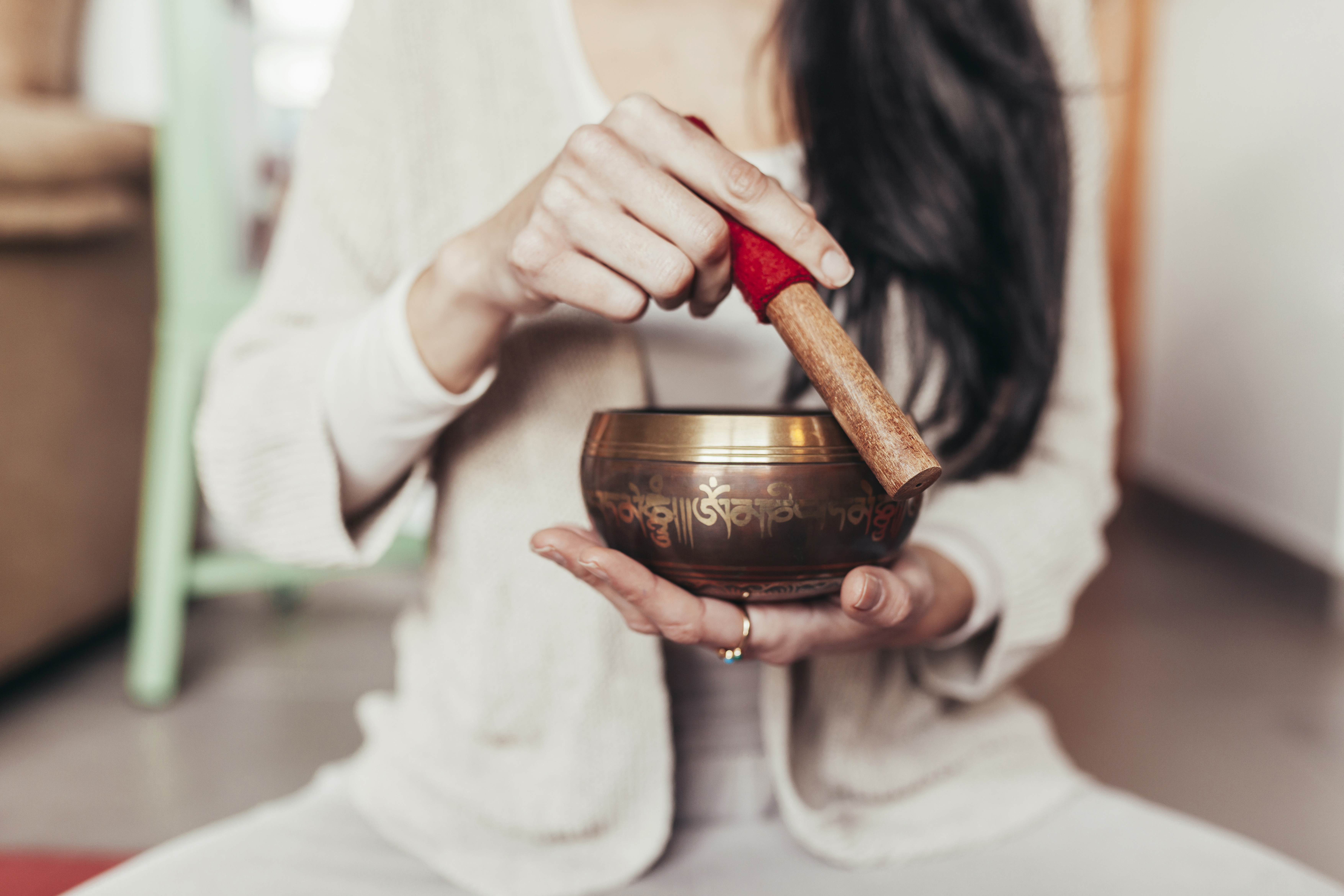 Unknown woman meditating with singing bowl