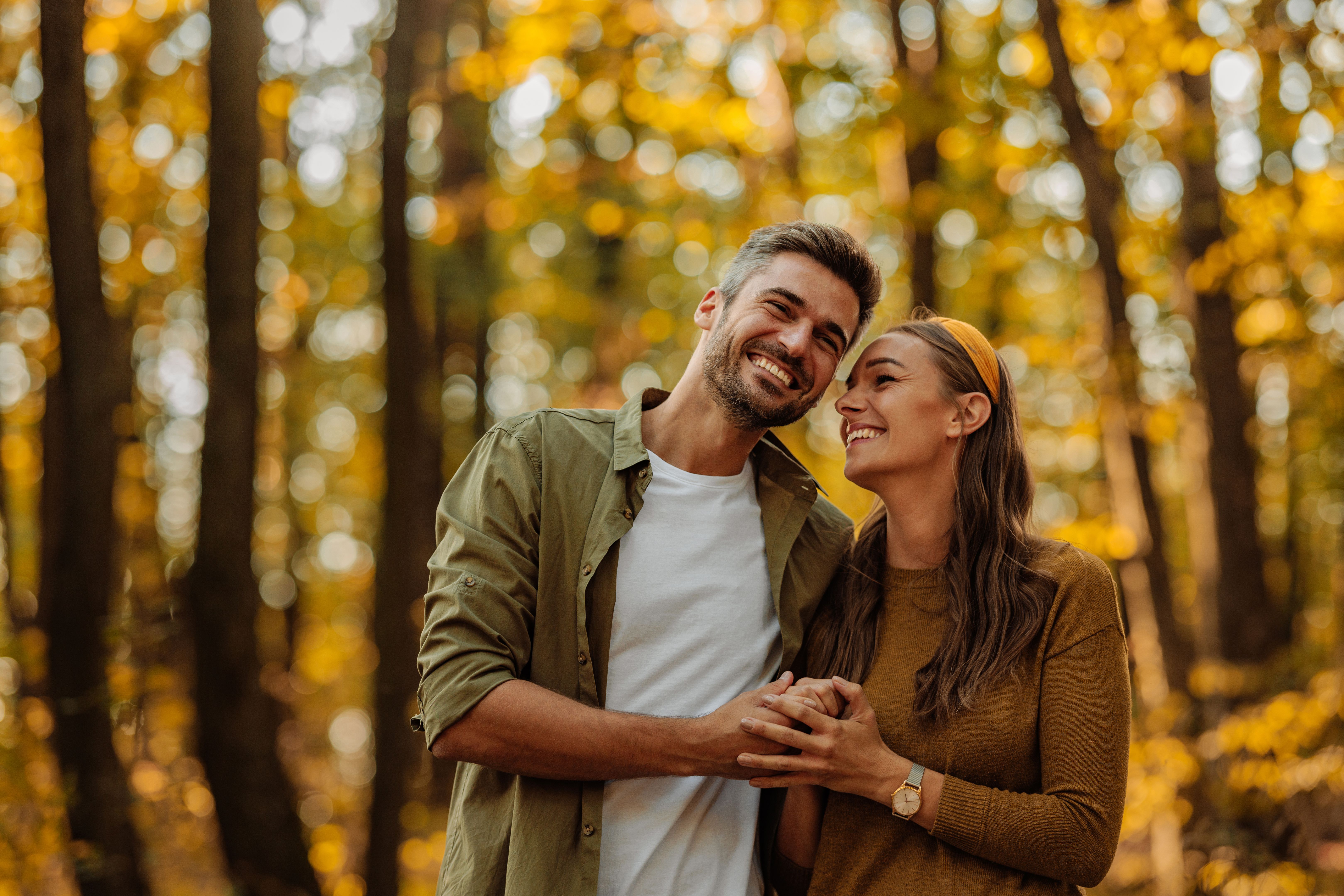 Happy couple in love hugging and walking in the forest Happy couple in love hugging and walking in the forest