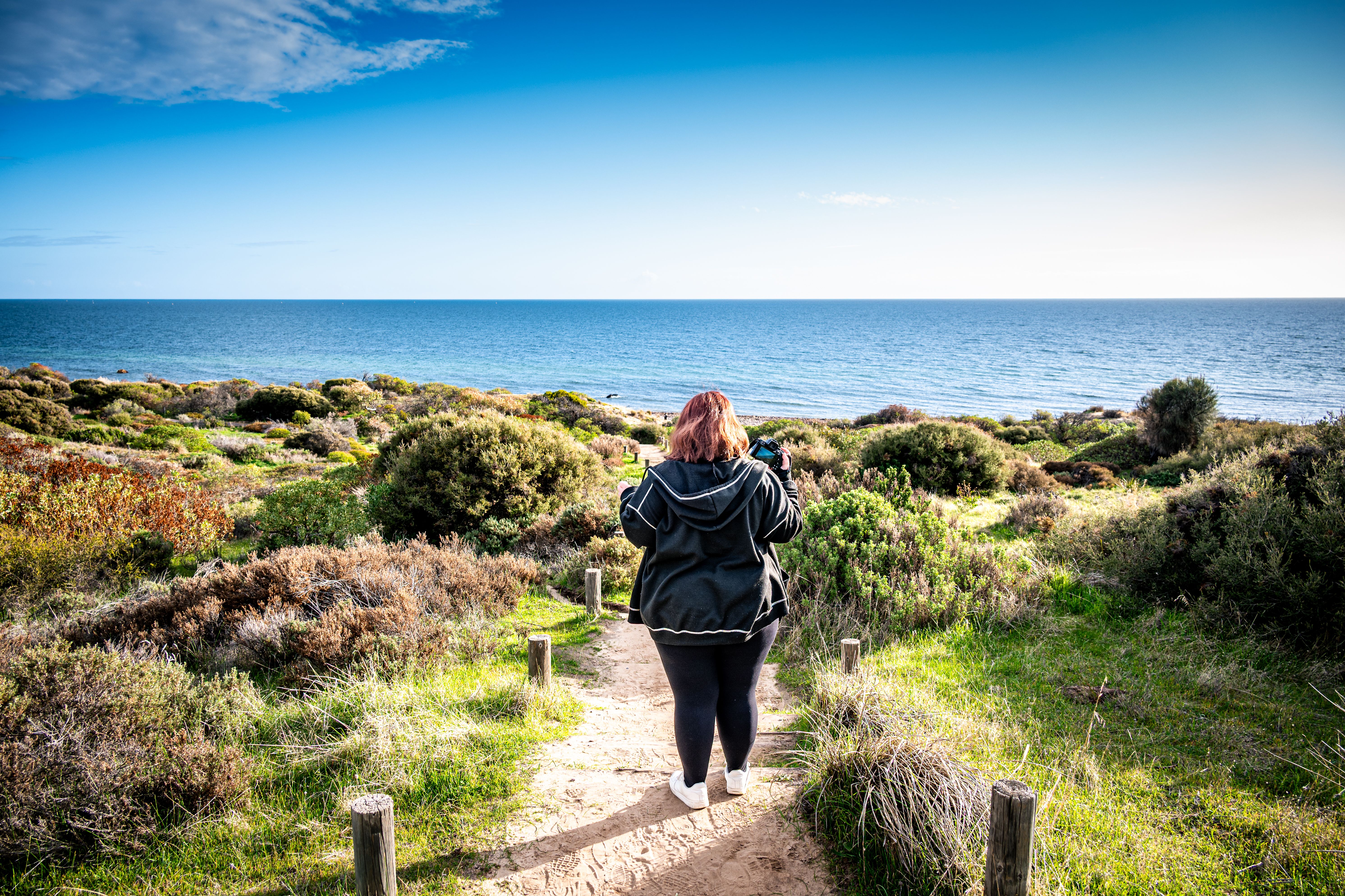 Photographer Walking Toward the Ocean Through Coastal Bushland Sand Path - Hallett Cove, South Australia
