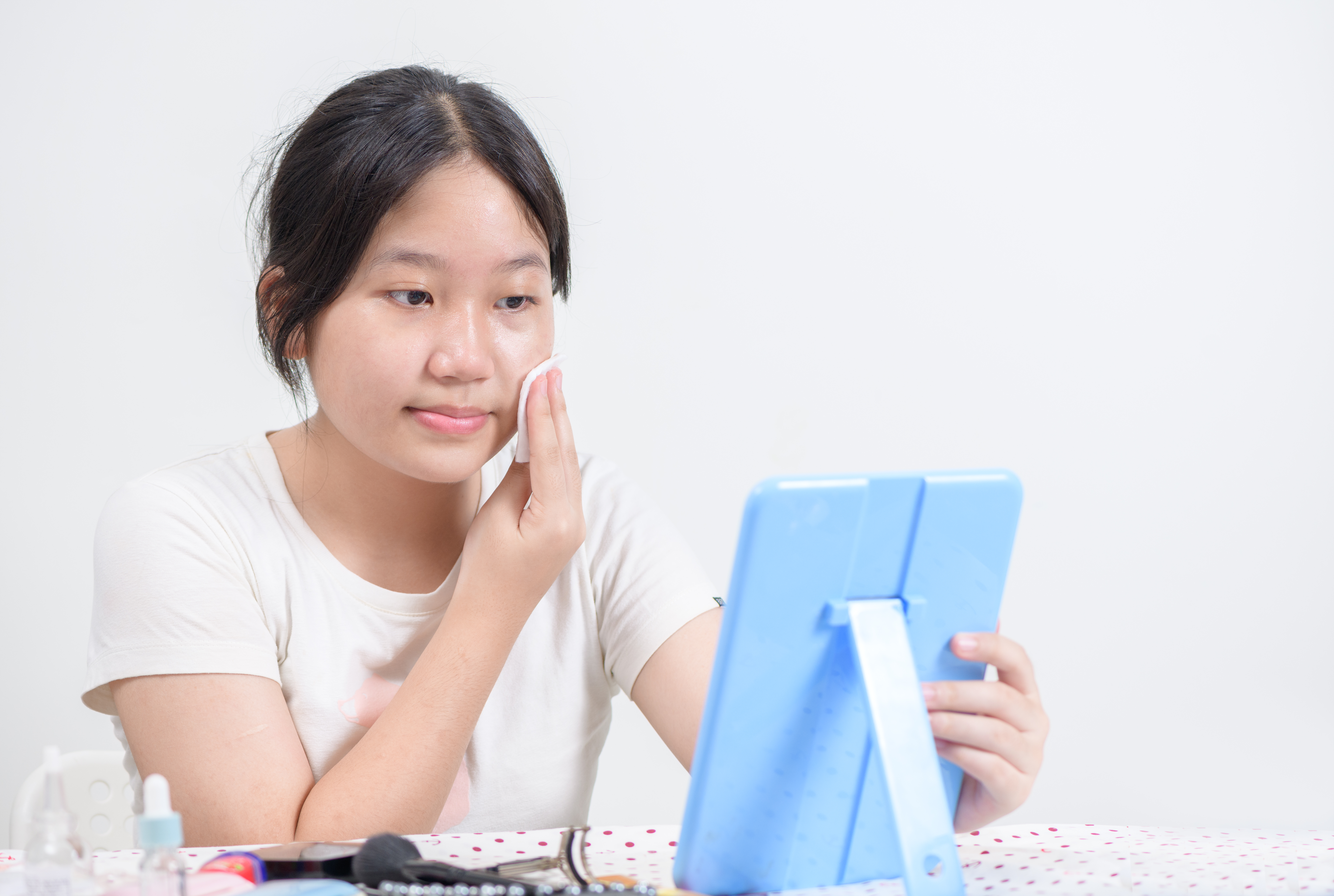 Cute asian girl uses cotton pad with toner for cleaning make up feeling so fresh and clean with healthy skin,