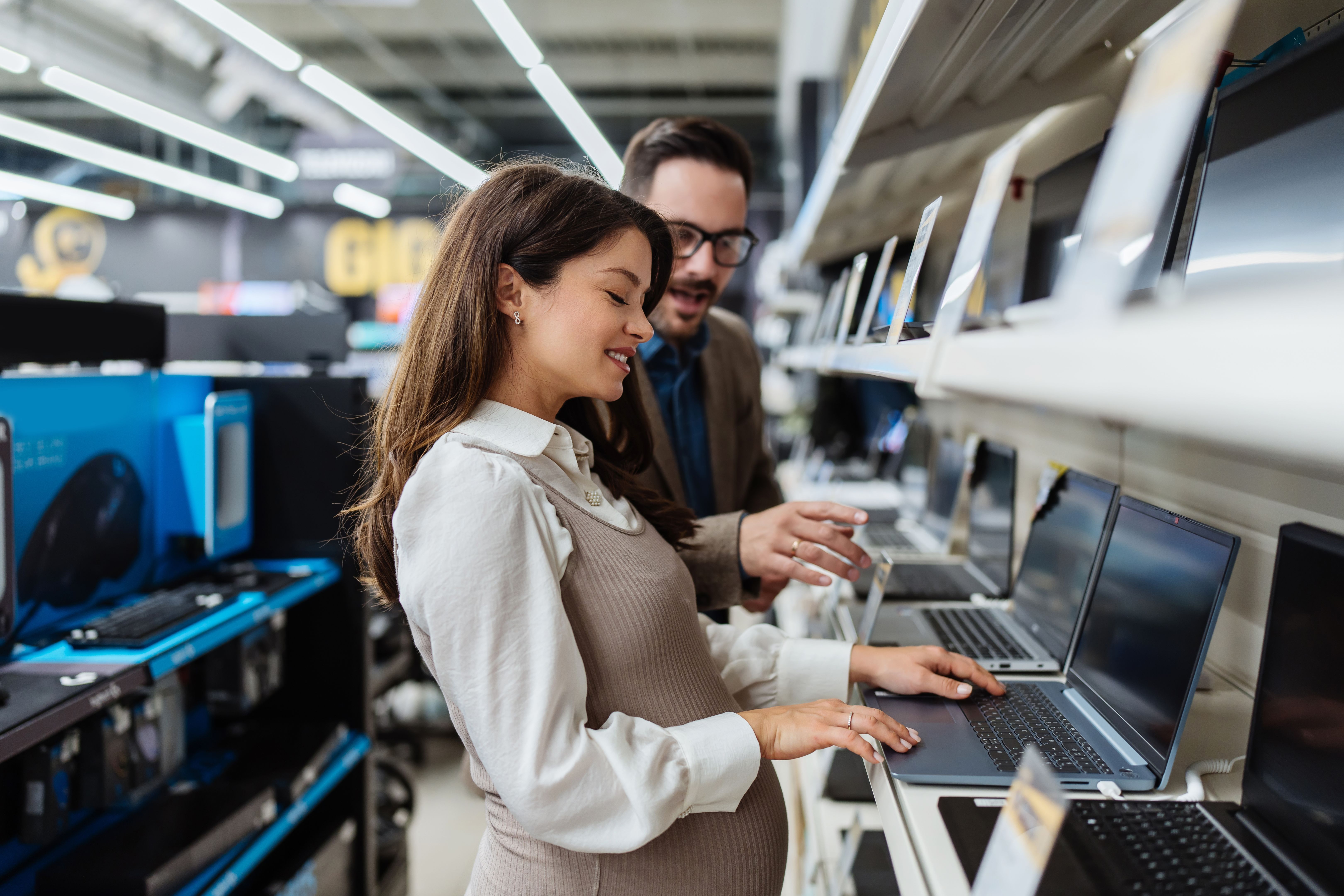 Young adult couple buyers in modern tech store.