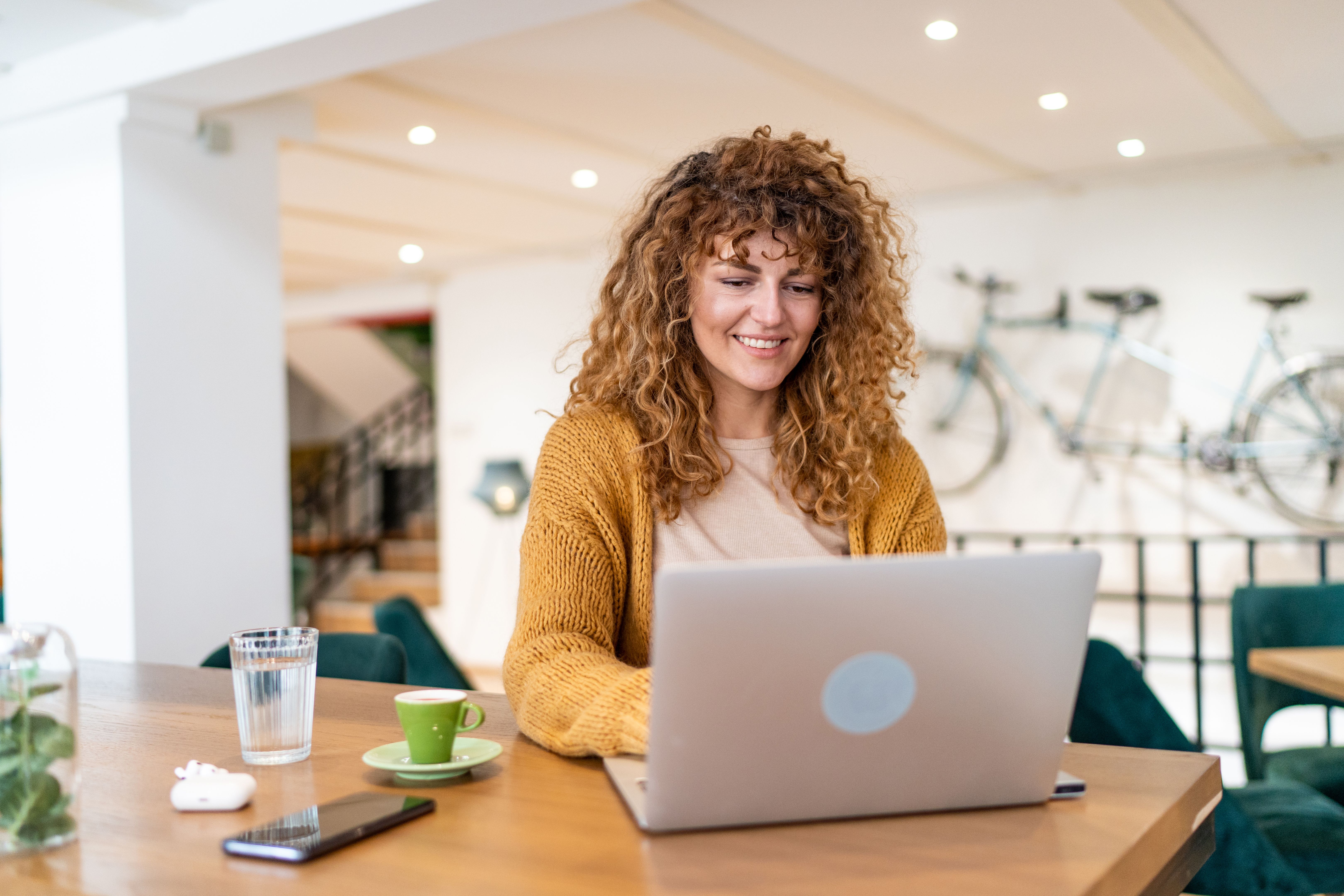 Happy young woman surfing the internet on a computer