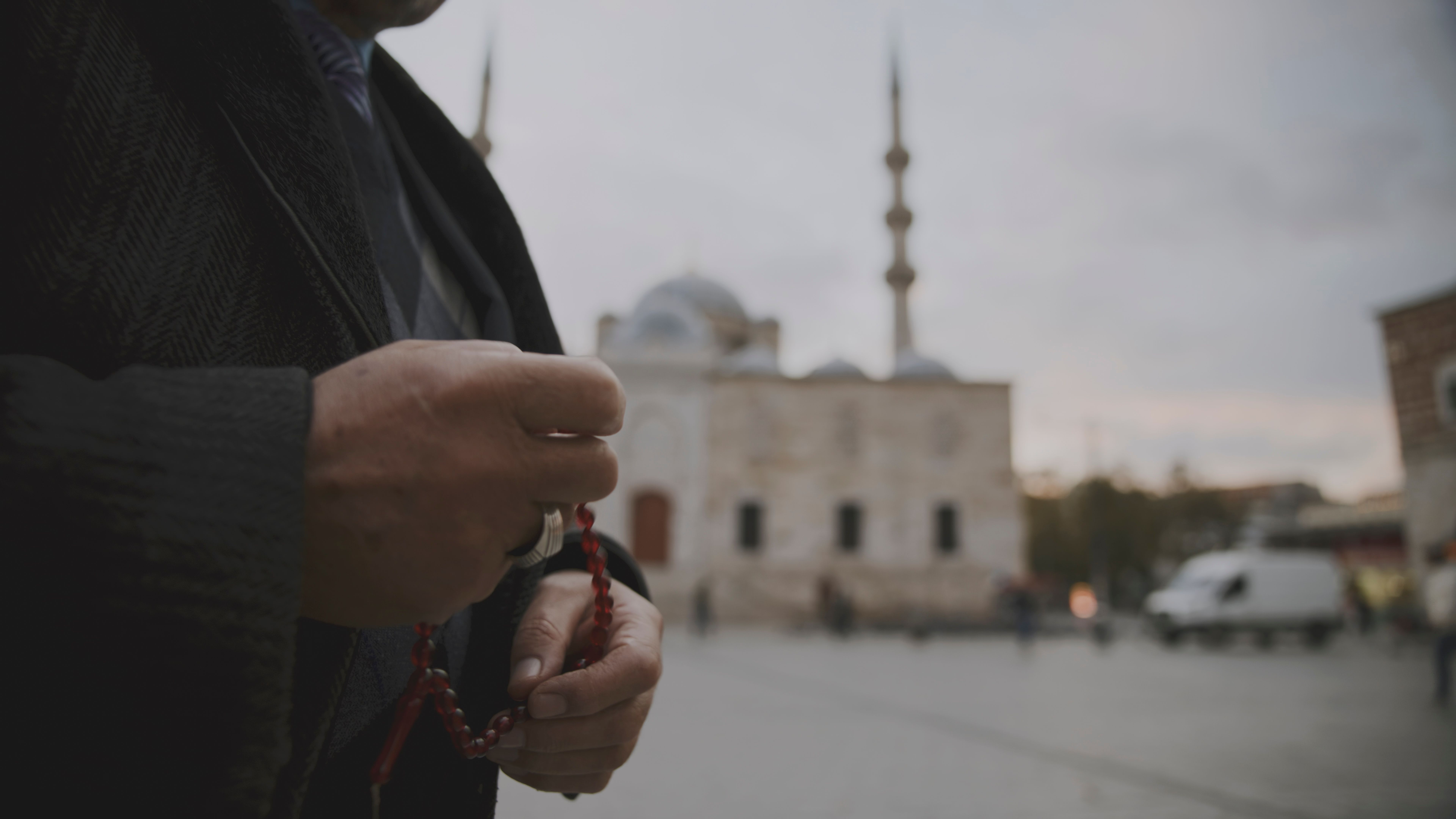 Midsection of Man Holding Prayer Beads on Street with Mosque in Background at Istanbul,Turkey Midsection of Man Holding Prayer Beads on Street with Mosque in Background at Istanbul,Turkey