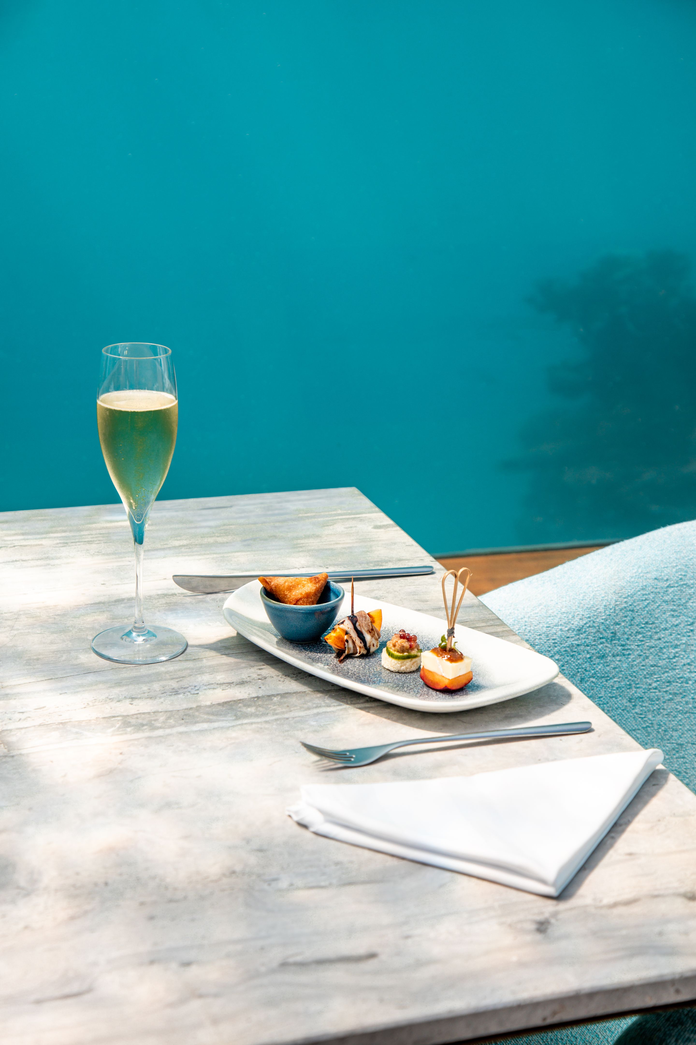elegant fine dining underwater restaurant table with champagne glasses and gourmet canapés served in luxury Maldives island resort hotel below water surface