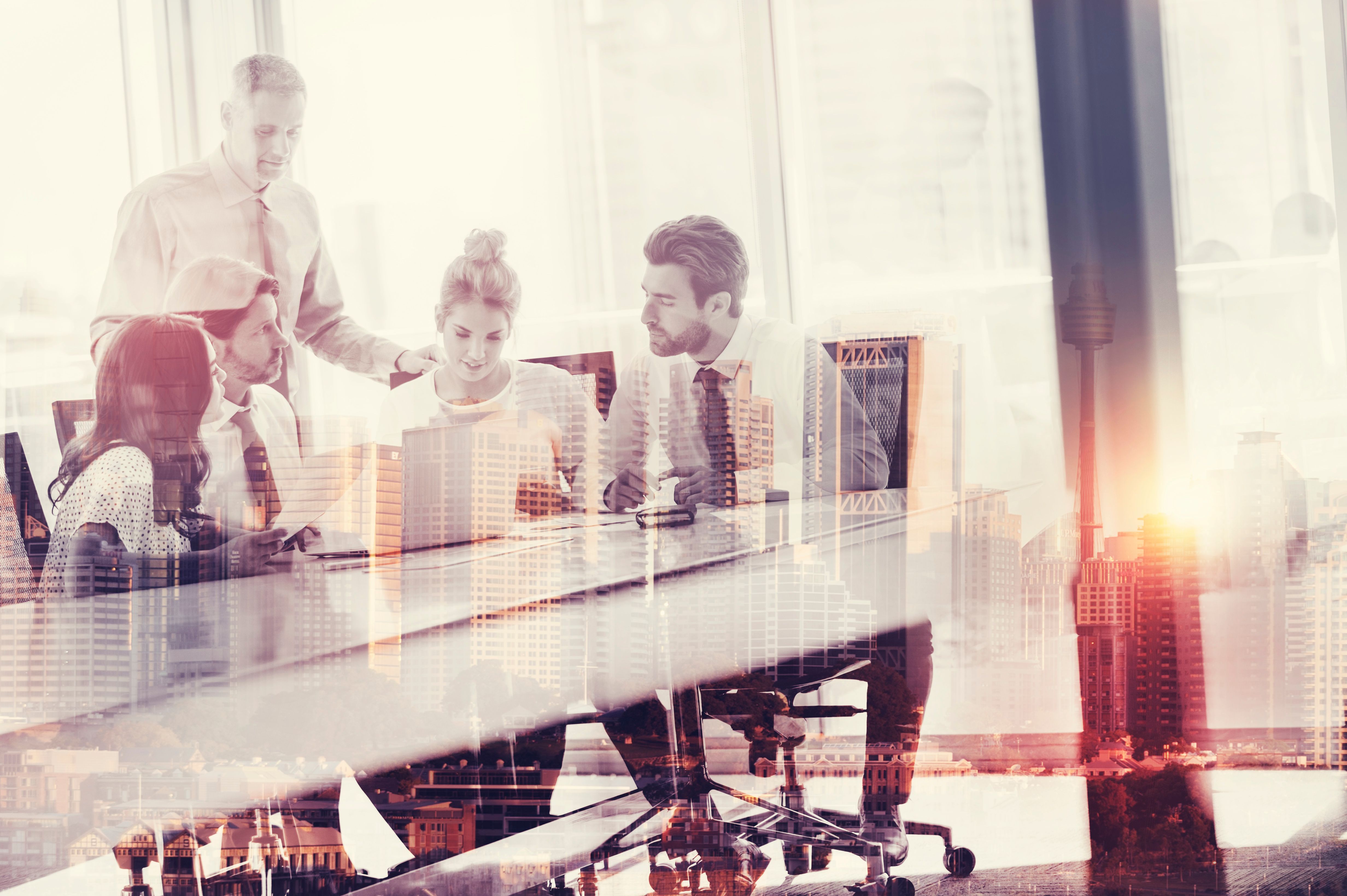 Montage of a team of business people working on laptop computer at the boardroom table.