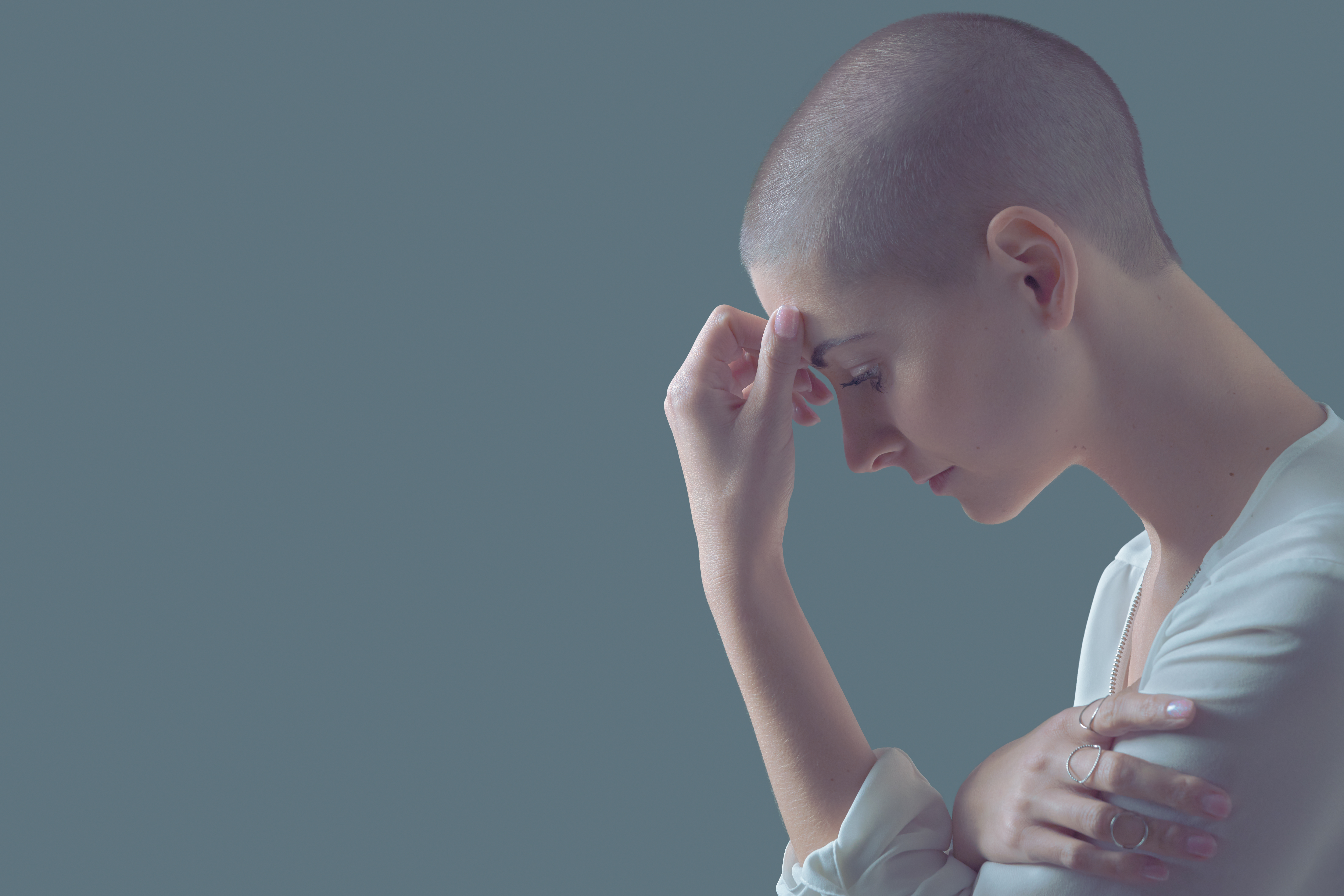 Sad, frightened and depressed female cancer patient portrait with copy space. Breast cancer patient, head in hands, portrait. Sad, frightened and depressed female cancer patient portrait with copy space. Breast cancer patient, head in hands, portrait.