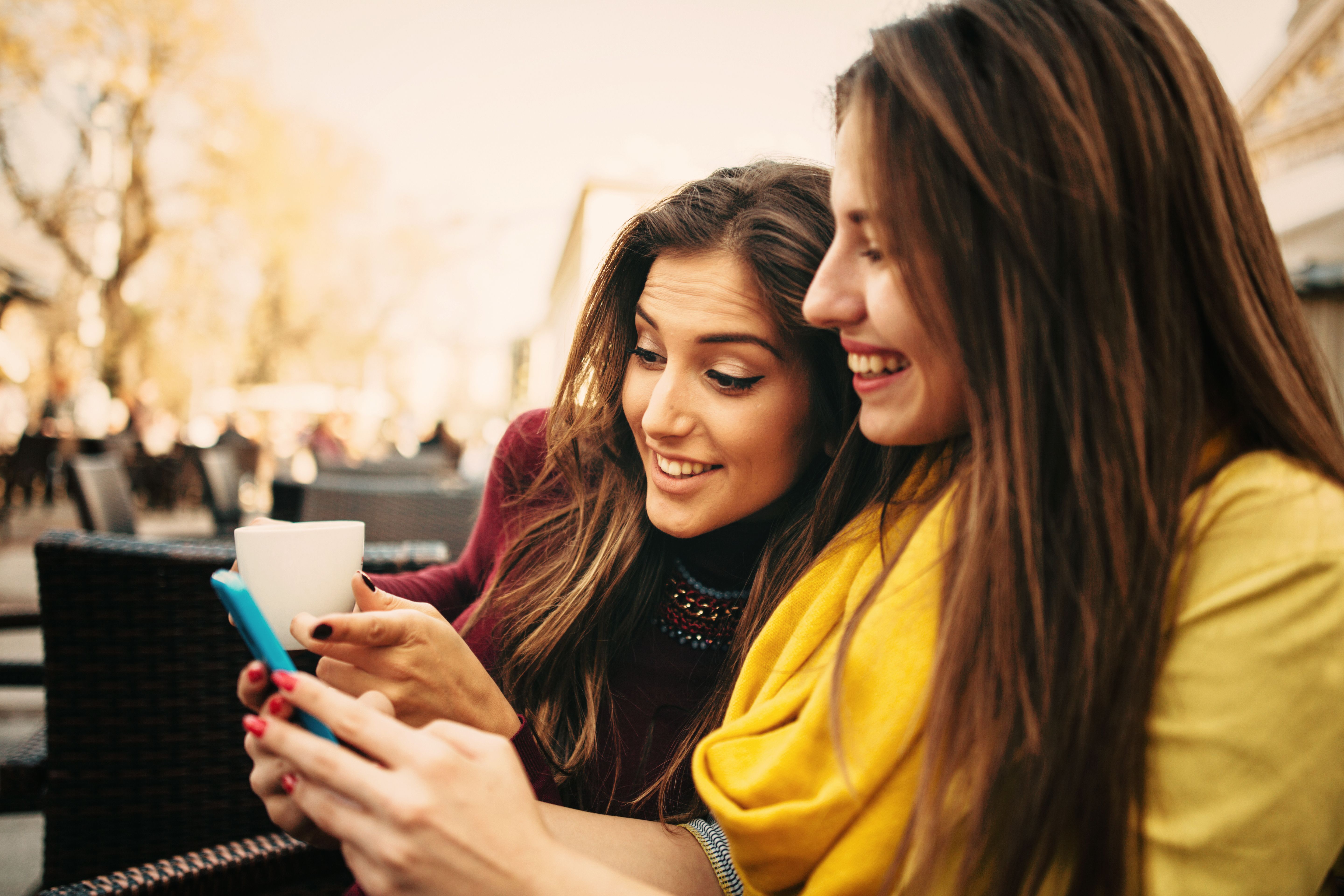 Friends Texting At The Cafe