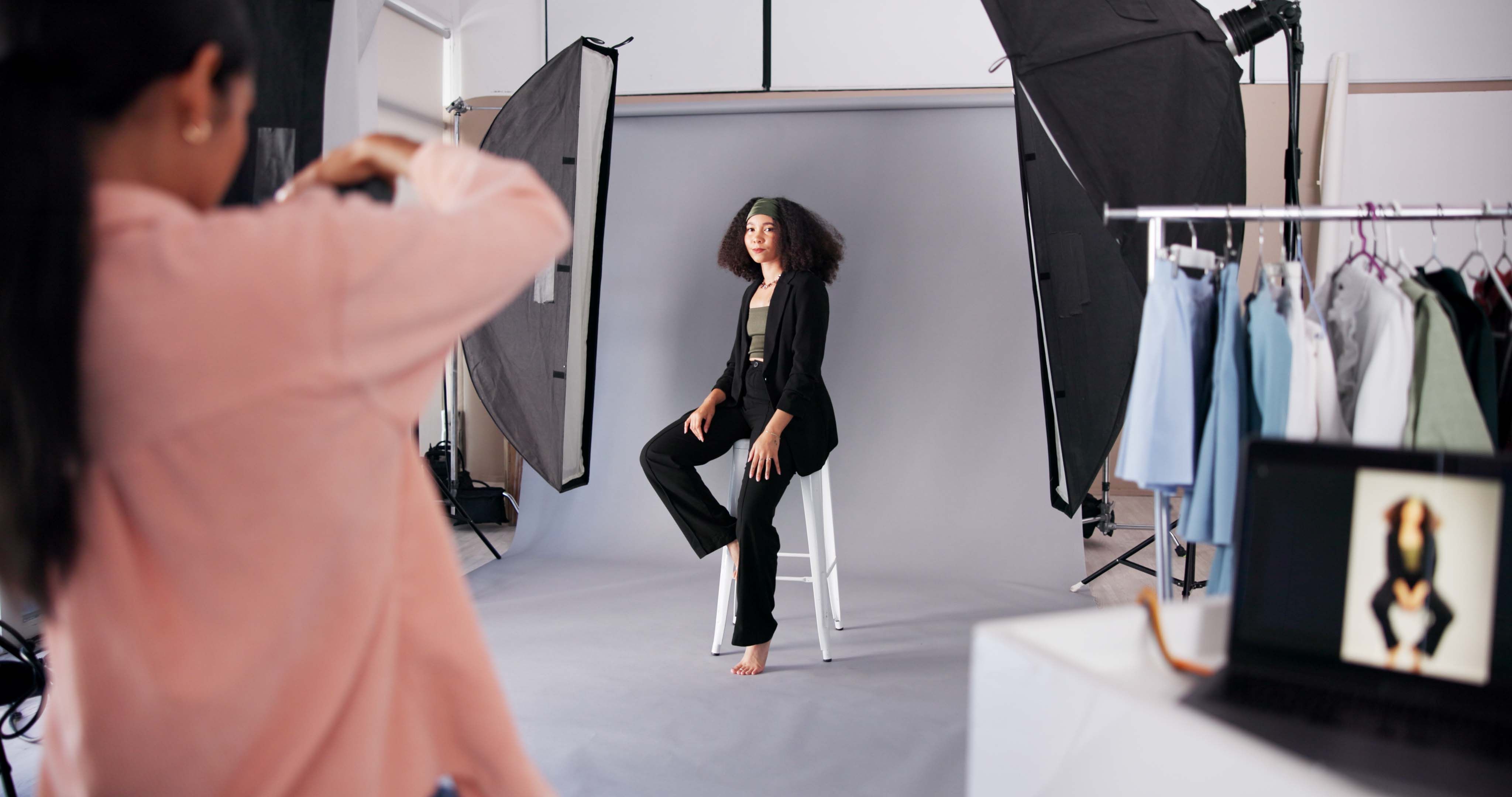 Production, woman and studio photographer with model for magazine photoshoot, media or picture. Camera pose, professional photography and fashion on set, creative process and designer advertising