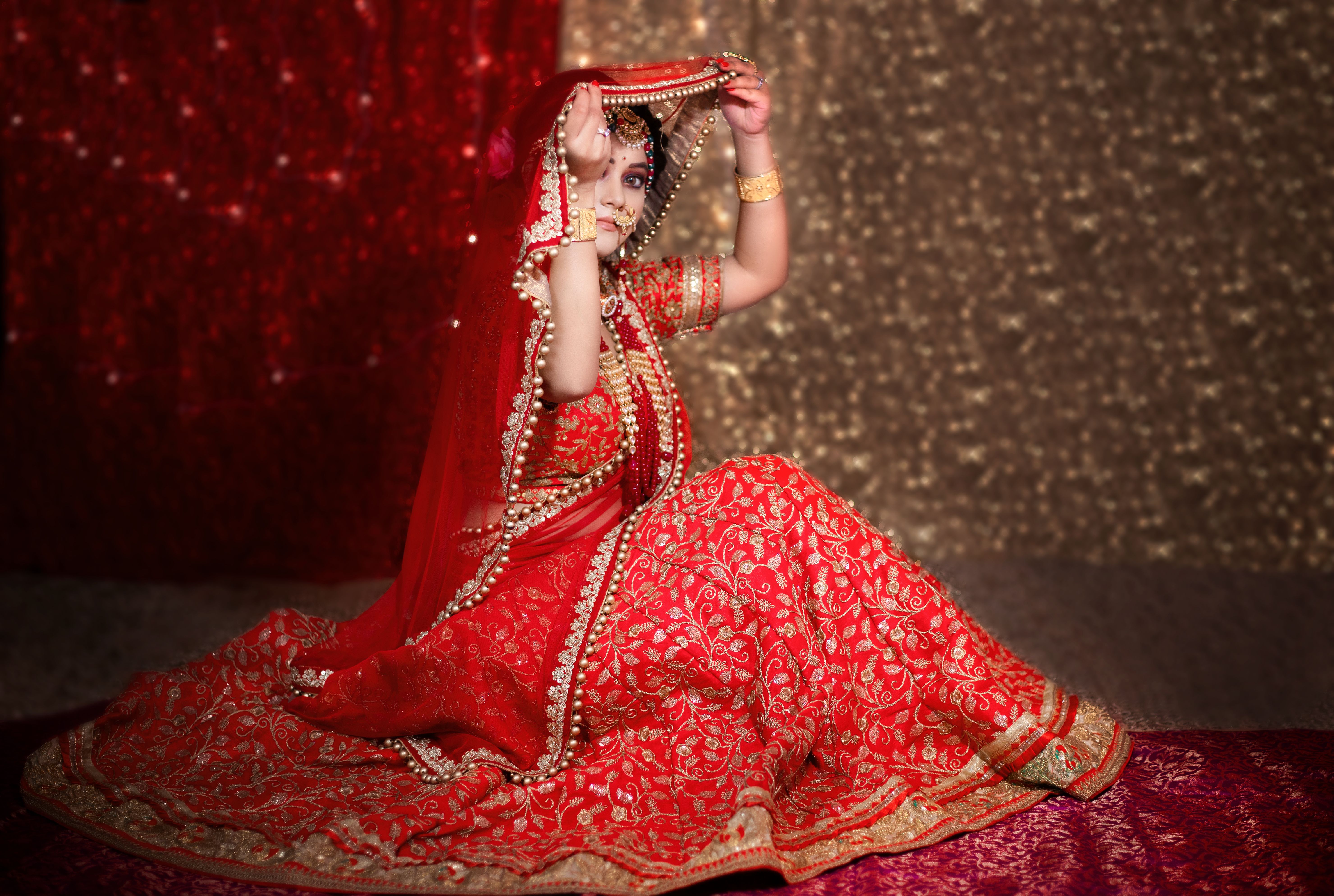 Beautiful indian girl in bride look wearing red lehanga and gold jewellery