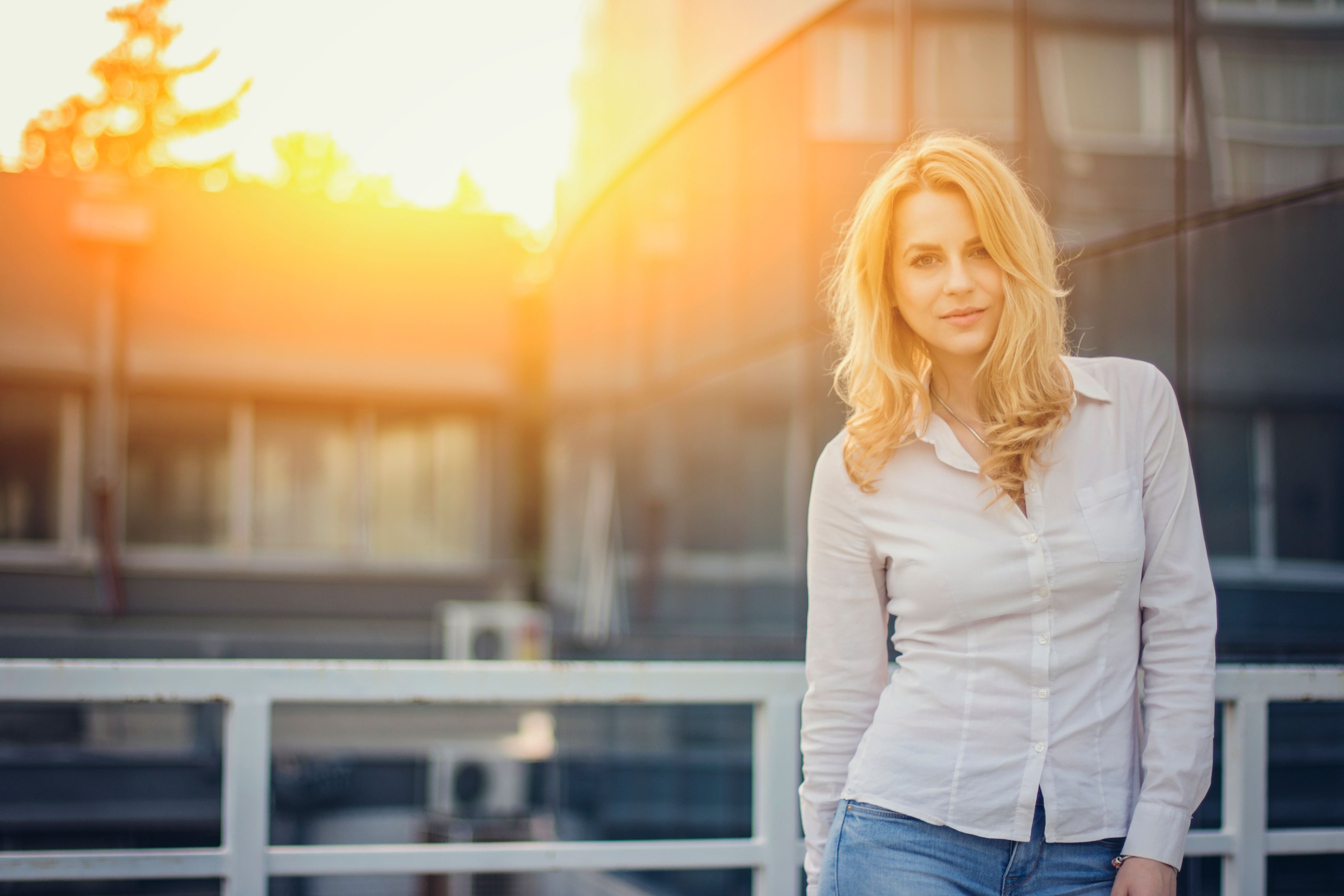 Beautiful woman in white shirt posing in front of building Beautiful woman in white shirt posing in front of building