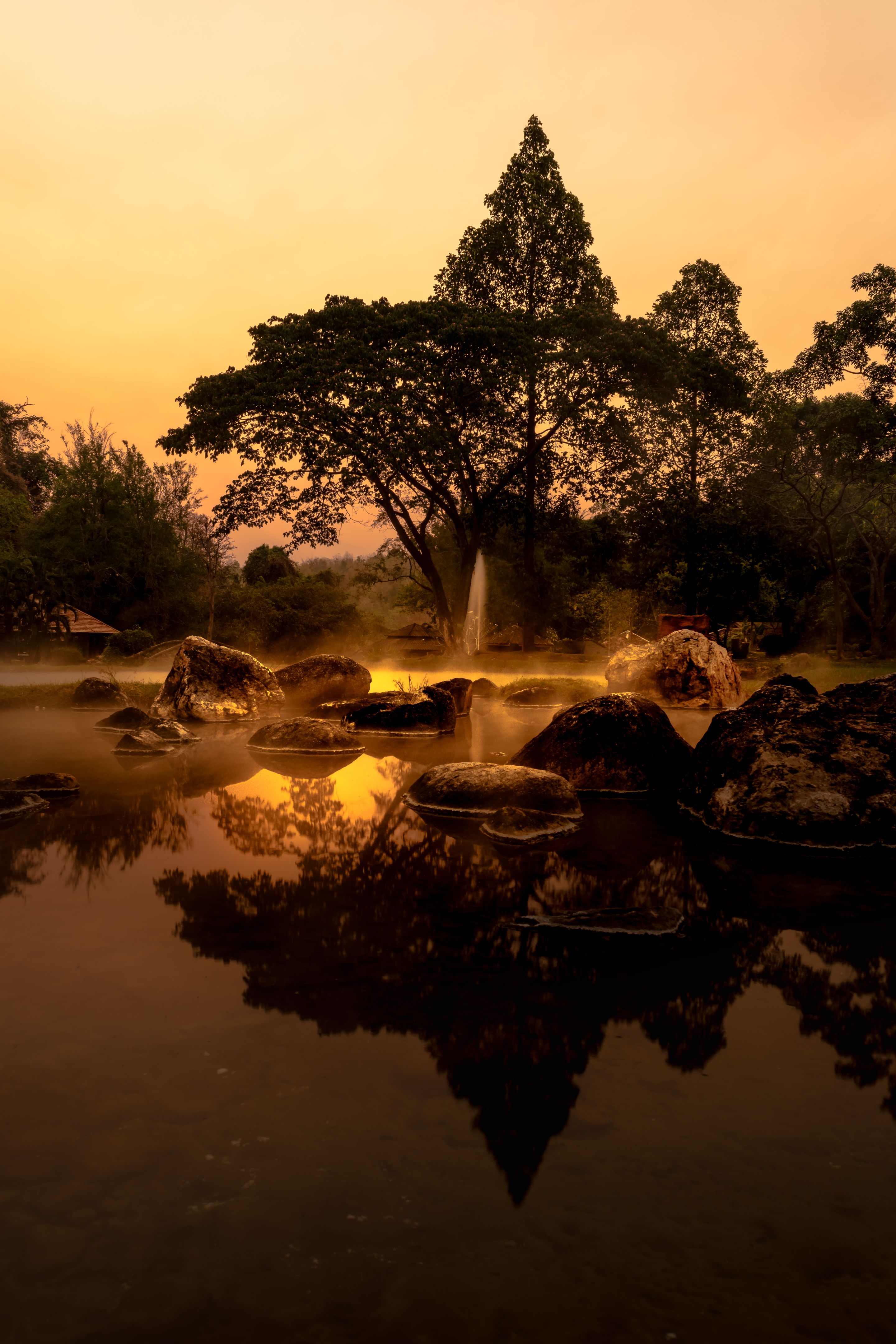 volcanic natural hot spring mineral water pool with steam spa and sun reflect light