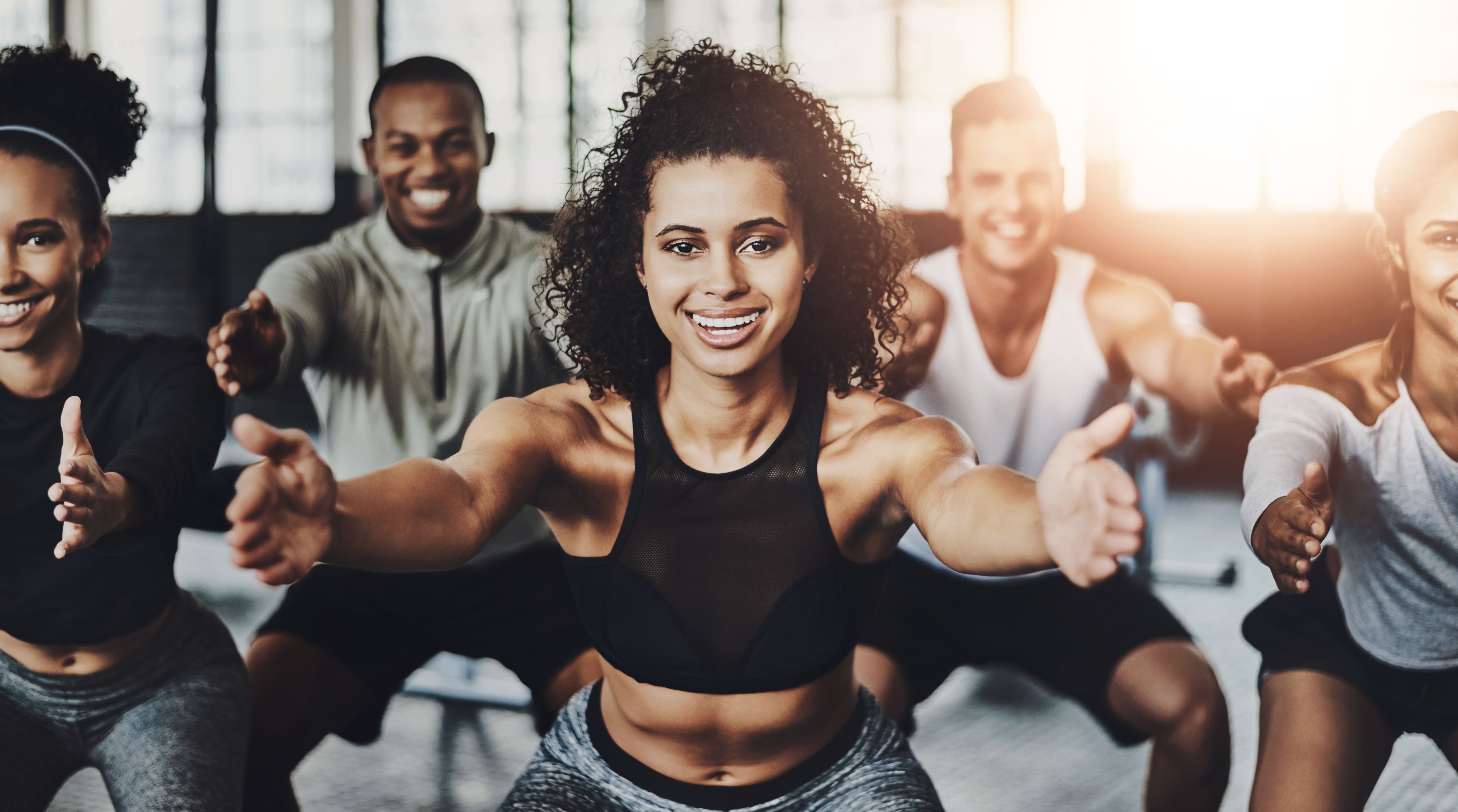 Portrait, people and squat for fitness, friends and health with exercise, motivation and endurance. Face, group and happiness in wellness center, training and practice with instructor and routine