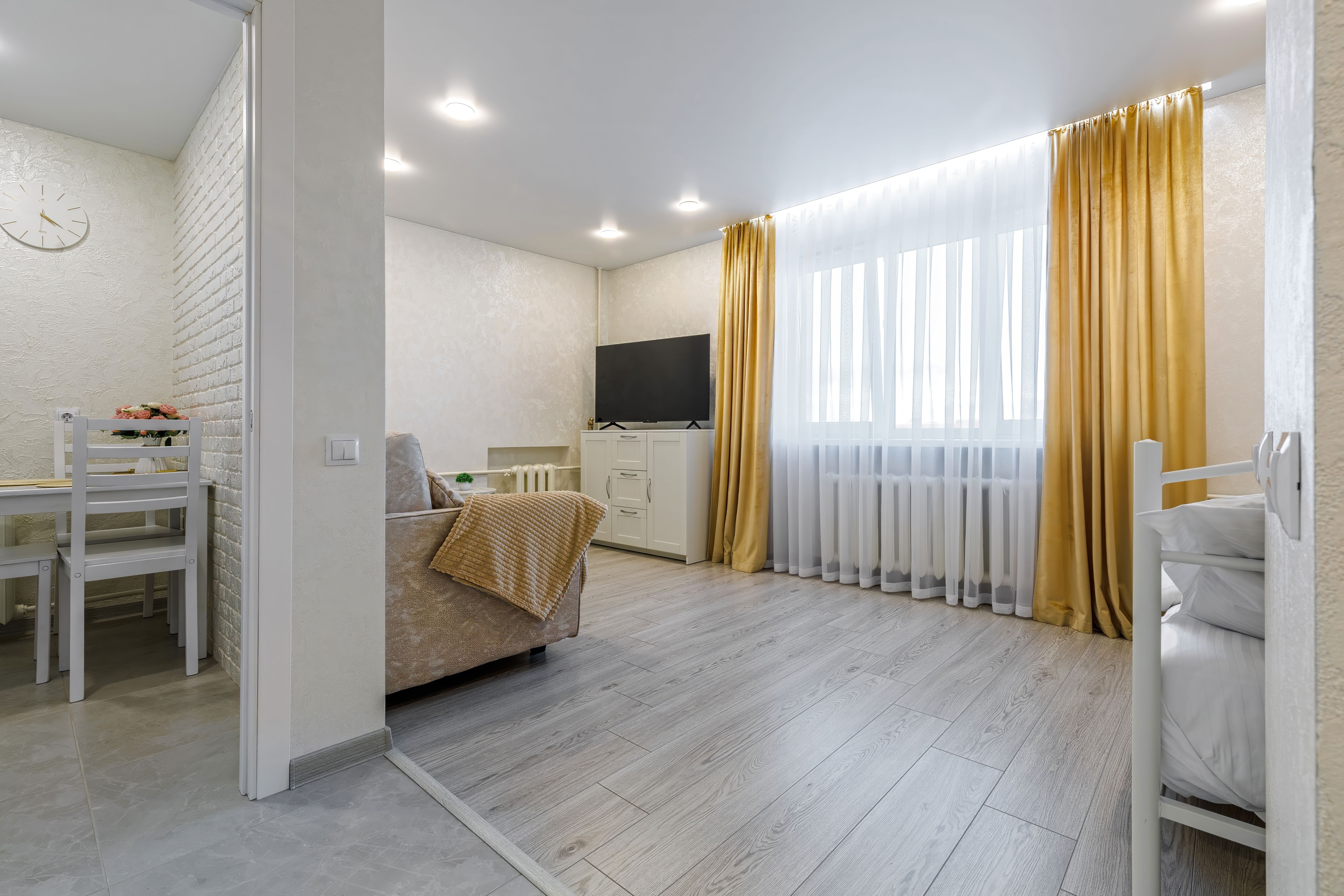 Cozy Living Room with TV, Sofa, and Yellow Curtains