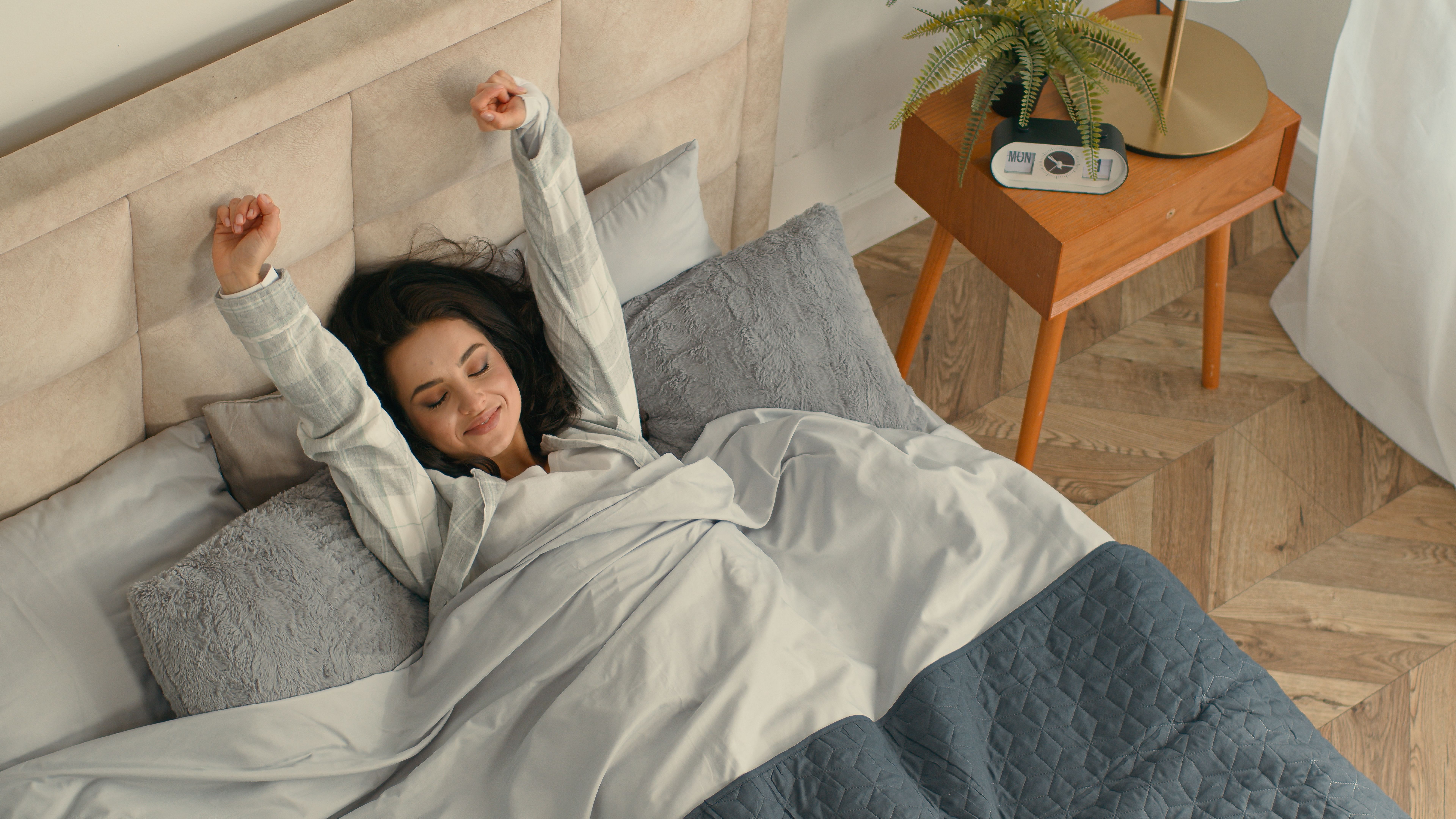 Happy woman stretching lying bed lazy comfortable girl female home hotel rest enjoyment smile good mood relaxed sleepy bedroom satisfaction pleasure weekend glad accommodation awaken daydream mattress