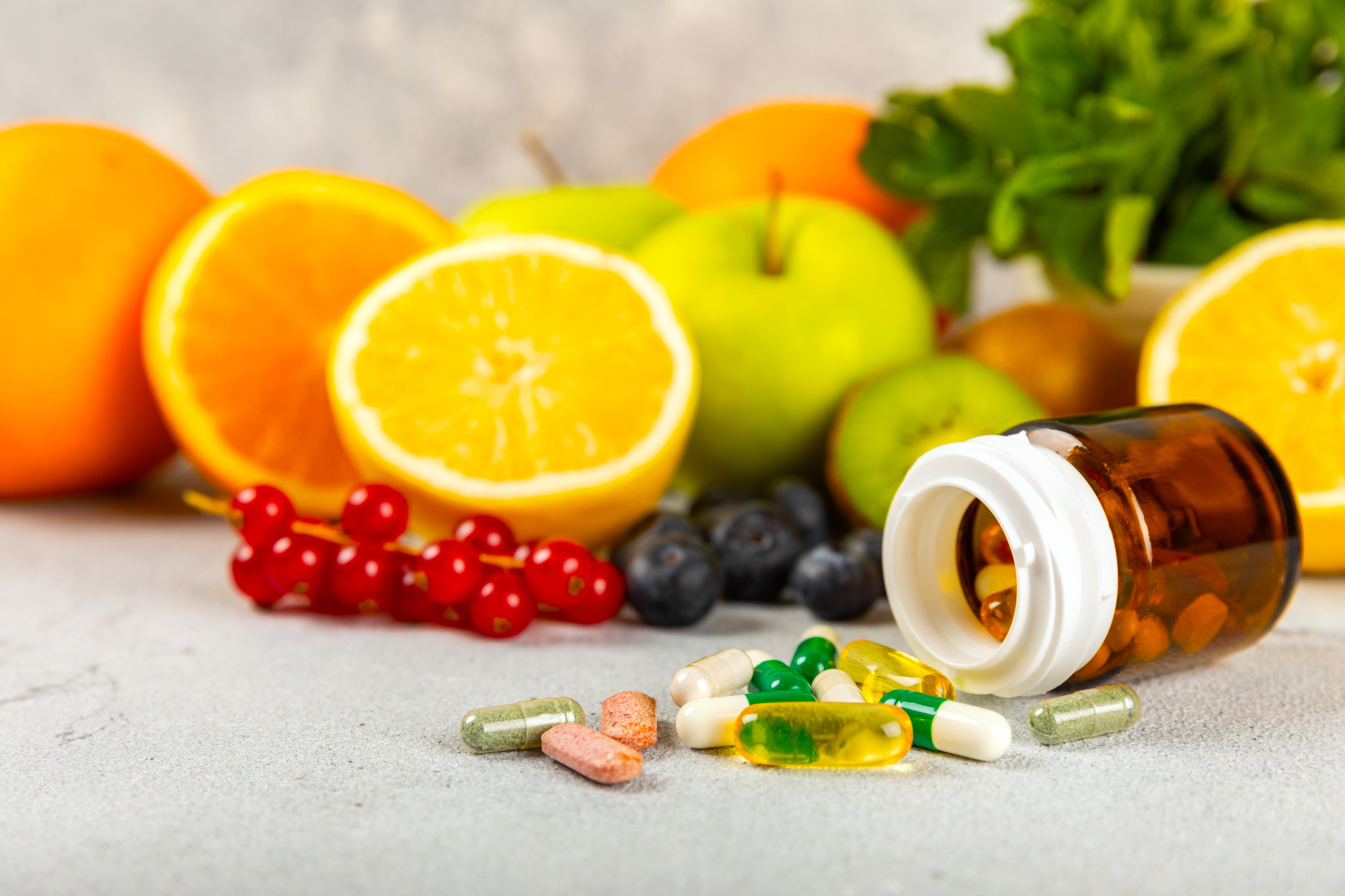 Vitamins and supplements. Variety of vitamin tablets in a jar on a texture background.Multivitamins with fresh and healthy fruits.Food supplements. Flat lay. Space for text.Copy space Vitamins and supplements. Variety of vitamin tablets in a jar on a texture background.Multivitamins with fresh and healthy fruits.Food supplements. Flat lay. Space for text.Copy space